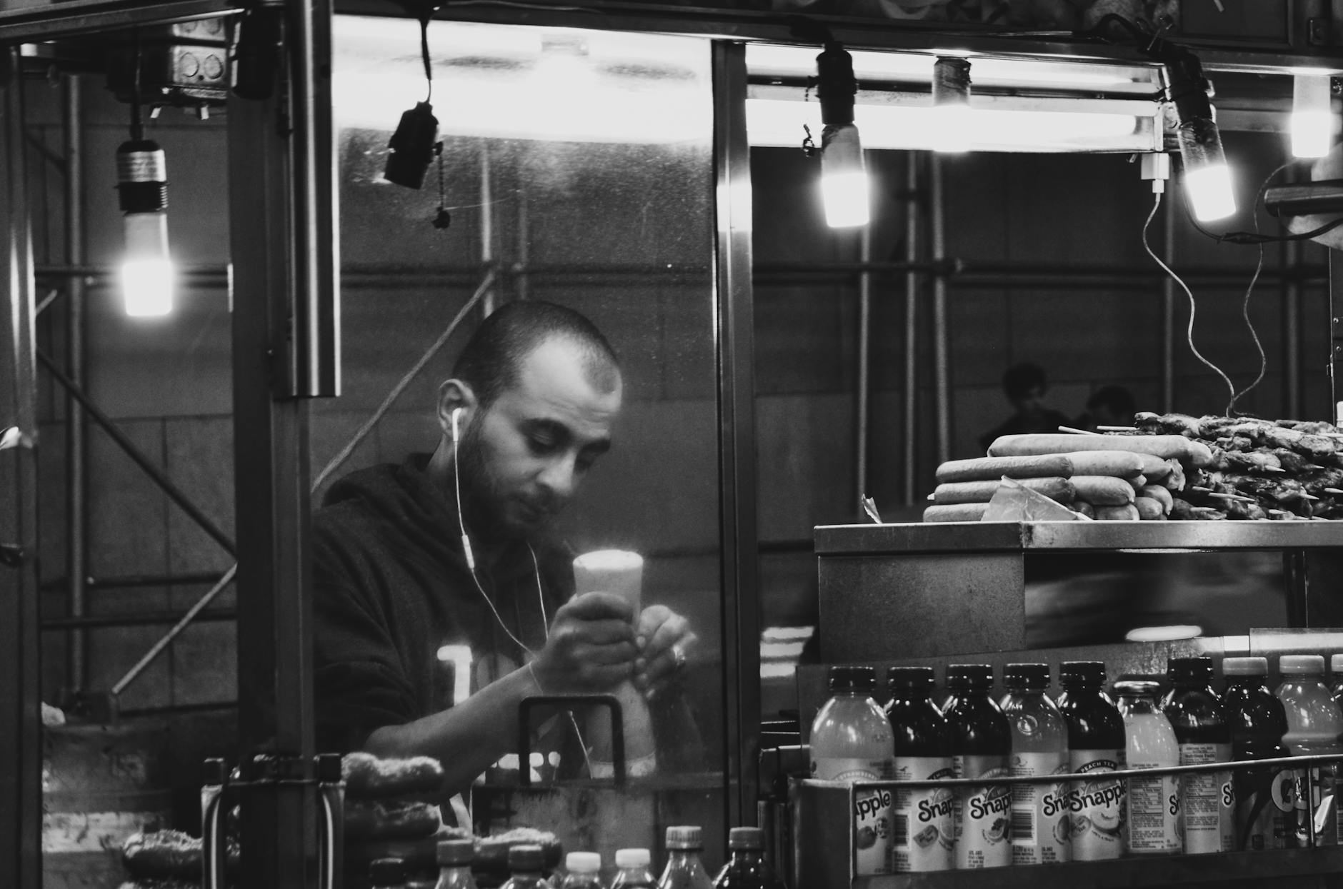 Capturing a New York City street vendor serving food at night.