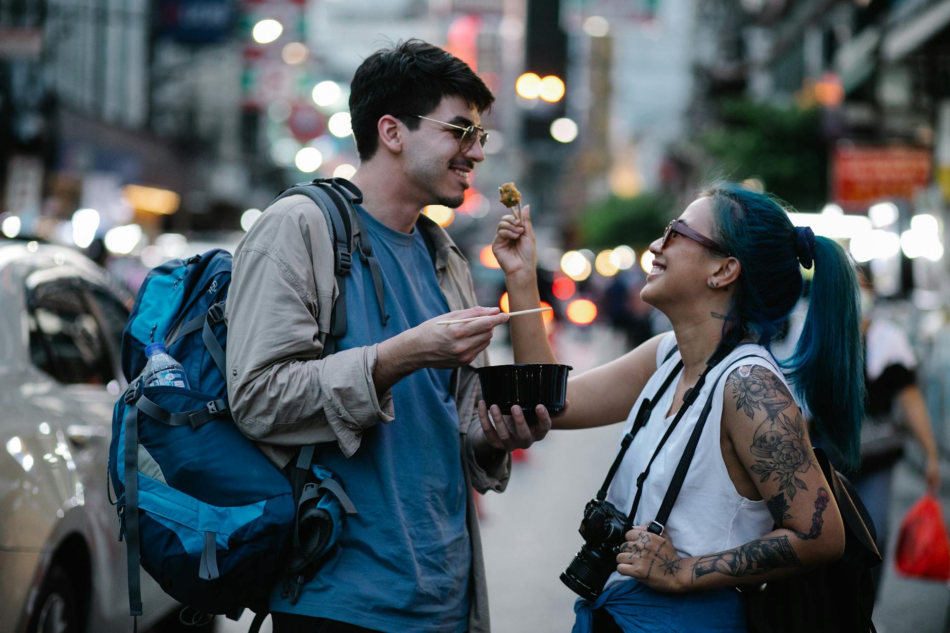 A couple enjoying street food in a lively city scene, capturing moments of joy and adventure.