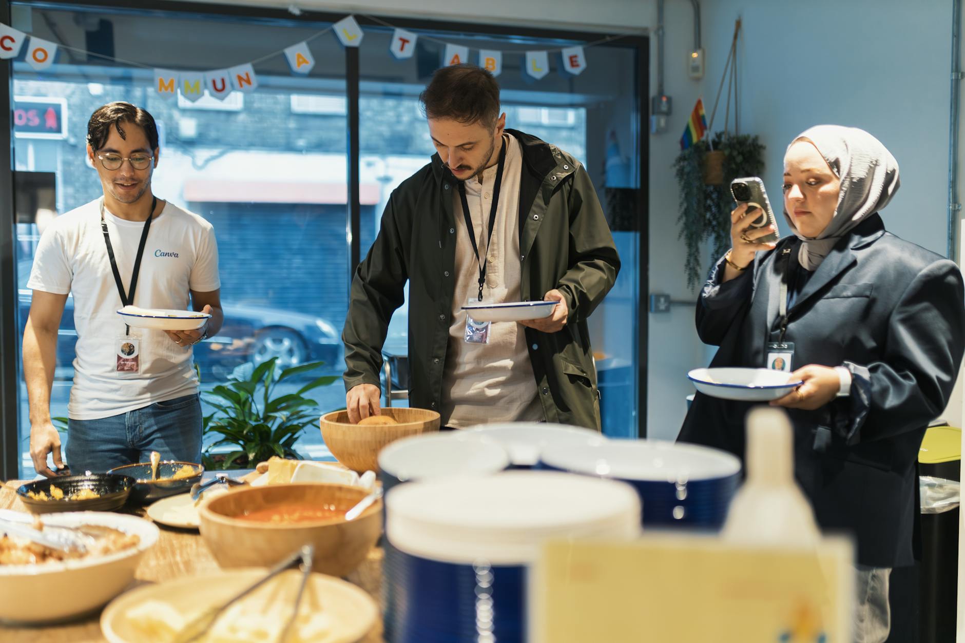 A diverse group of adults enjoying a casual buffet indoors with plates and food prepared for serving.