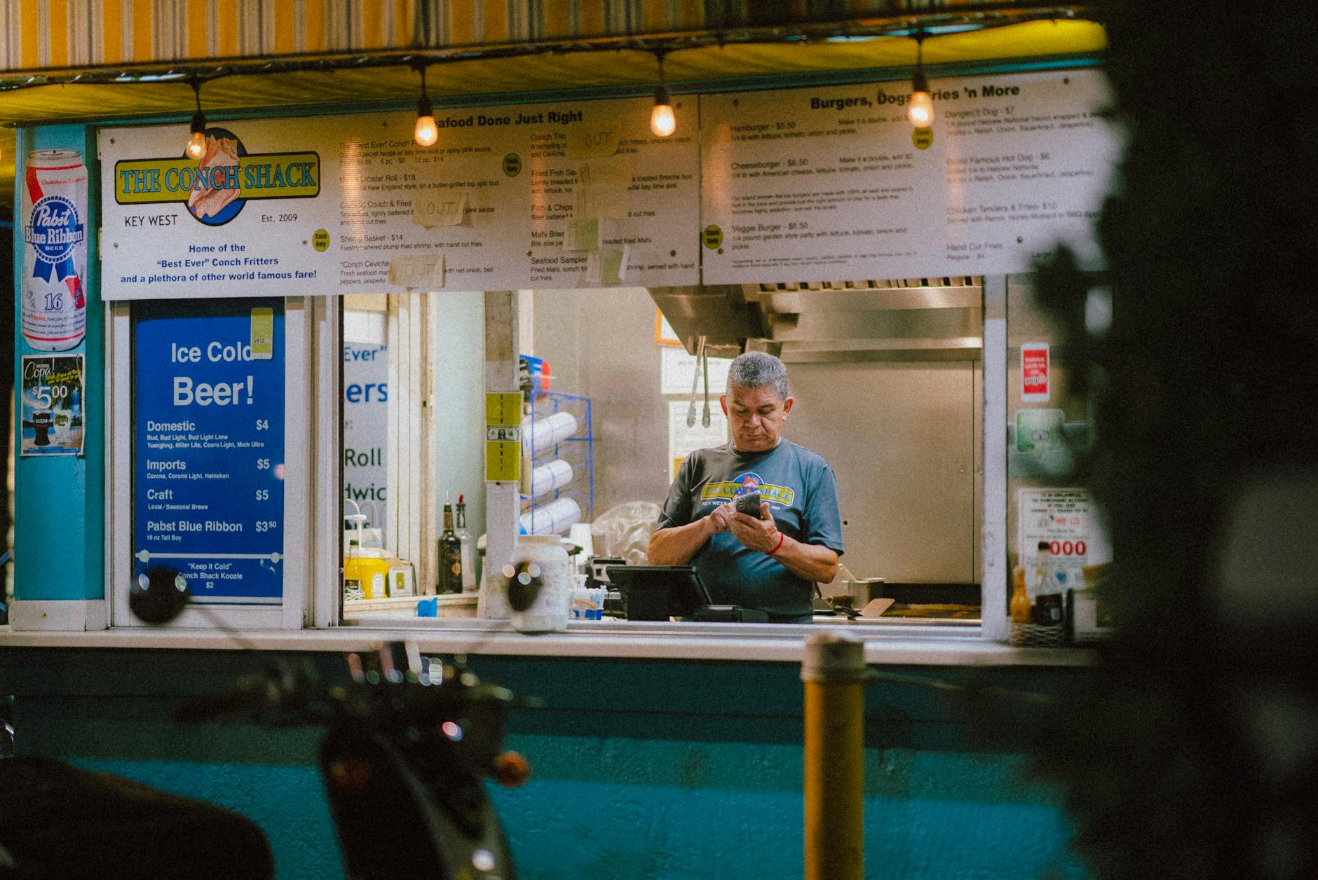 A street vendor in Key West, Florida serves customers at a food stand during the night.