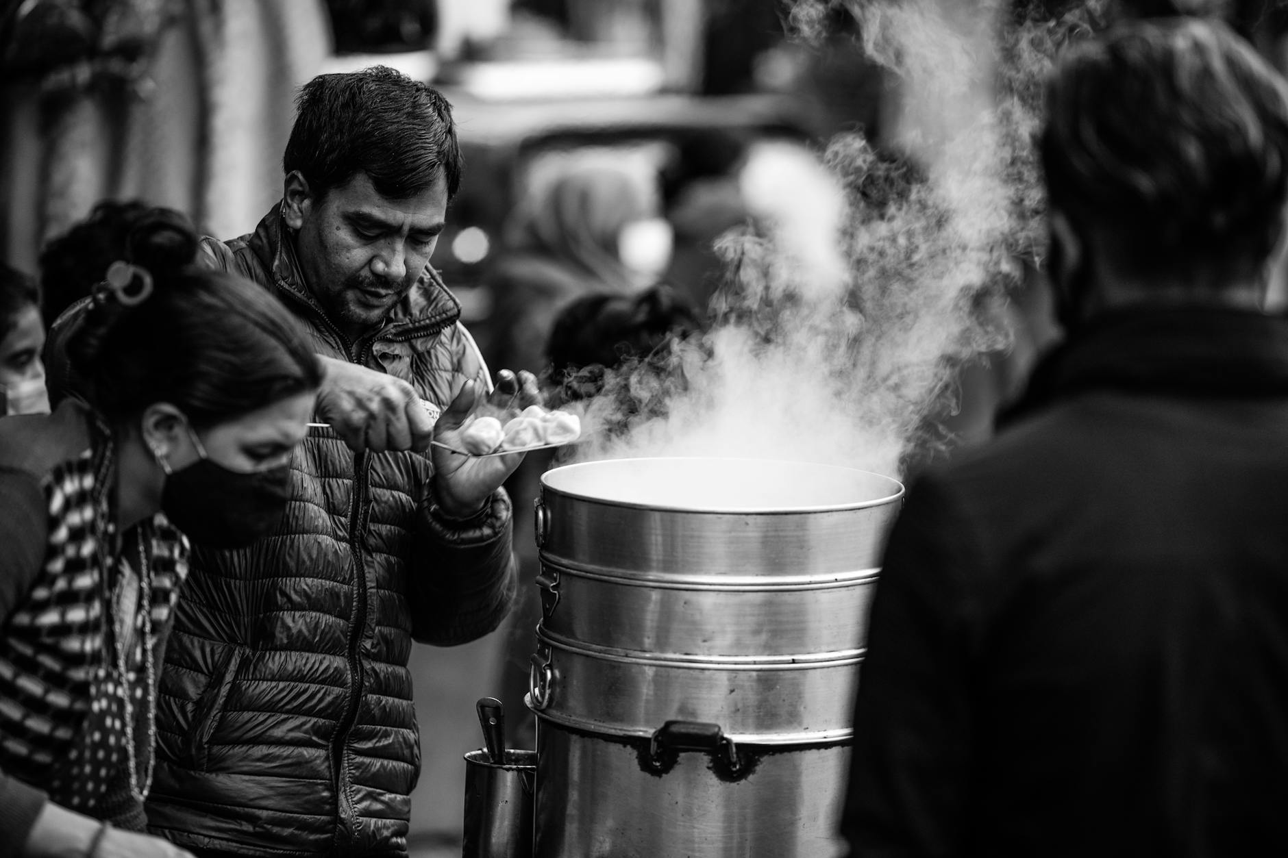 Black and white photo of street vendors serving traditional Nepalese food in Lalitpur.