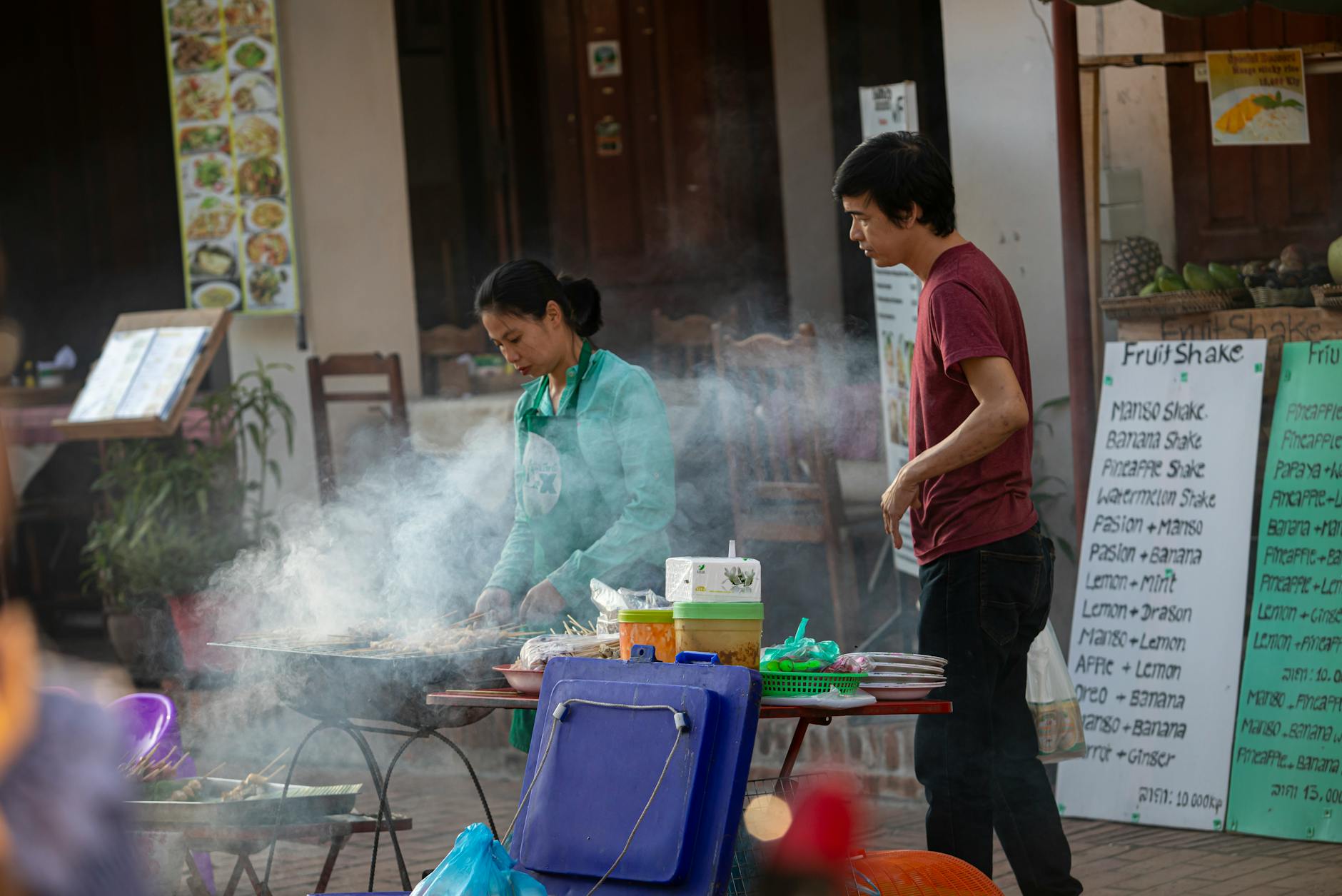 A bustling street food scene with vendors cooking amid urban city streets.