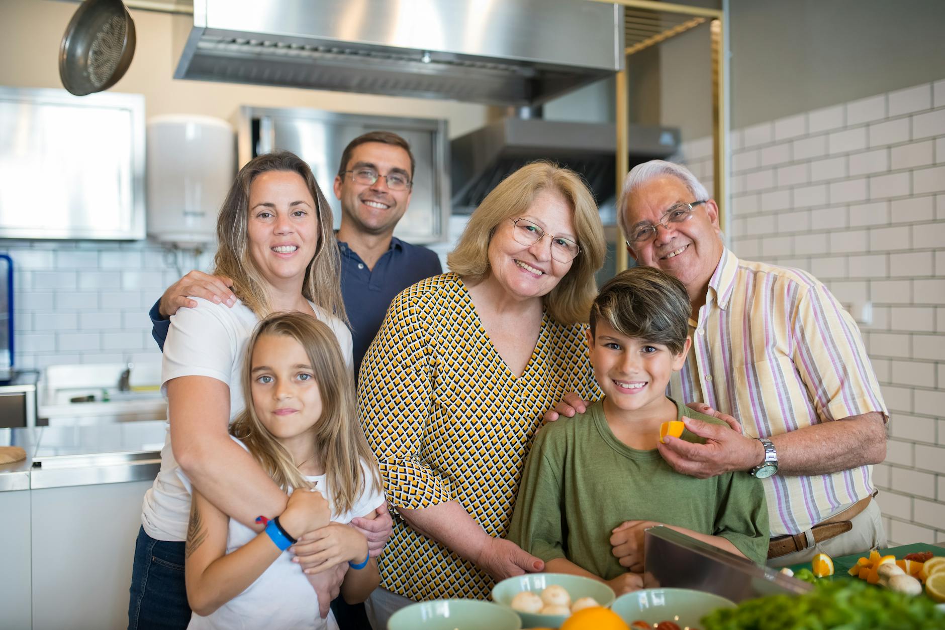 Happy family of six enjoying time together in a modern kitchen setting.