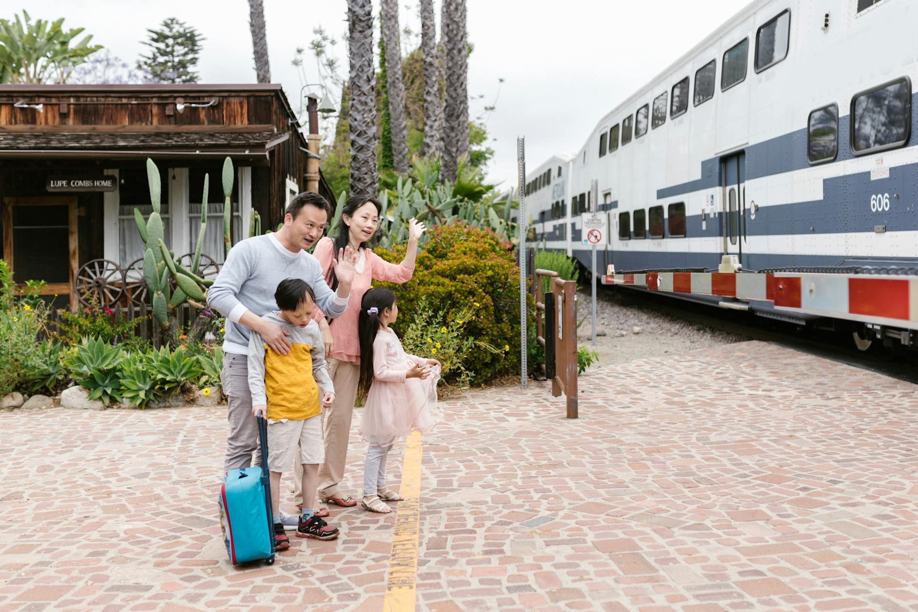 A family waves goodbye as a train departs, capturing a heartfelt moment at the station.