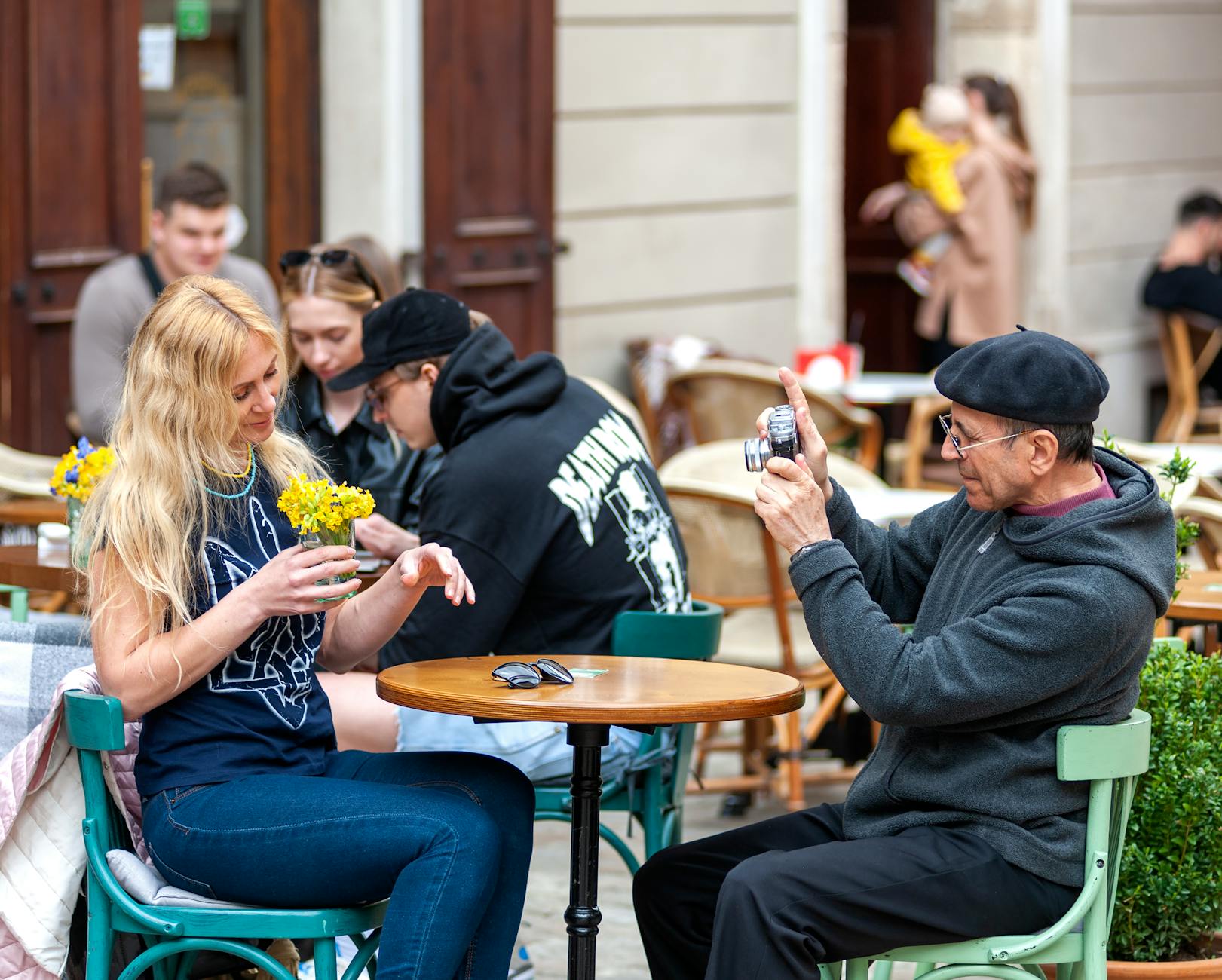A lively cafe scene in Lviv with people enjoying an outdoor setting on a sunny day.
