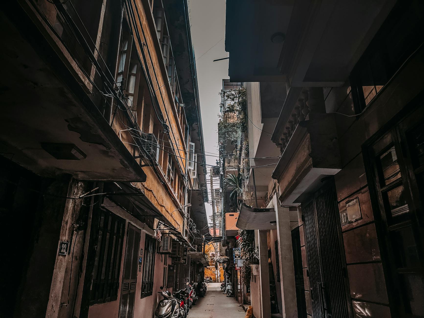 Explore a picturesque narrow alleyway in Hanoi, brimming with character and urban charm.