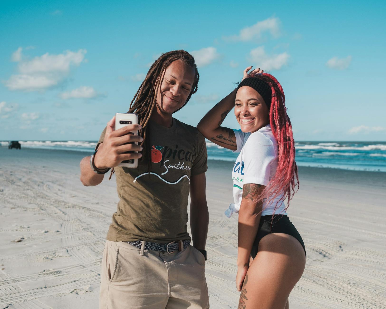 Happy couple capturing a selfie on a sunny day at New Smyrna Beach, Florida.