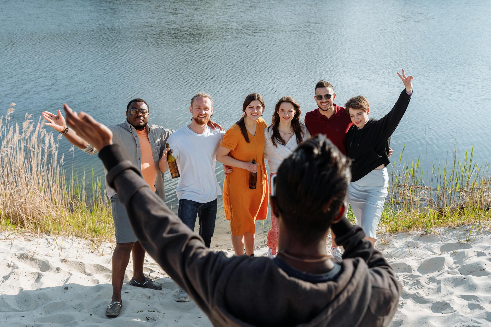 A group of friends enjoying a sunny day by the lake, taking a joyful photo together.