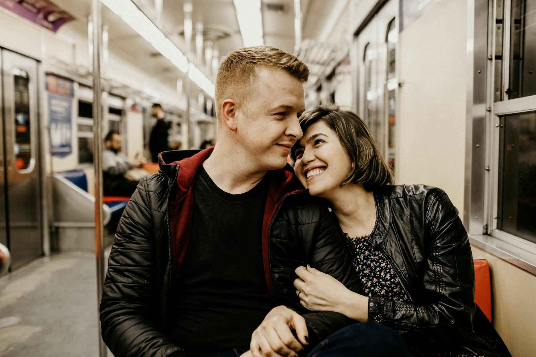 Young couple sharing a tender moment together on a train journey.