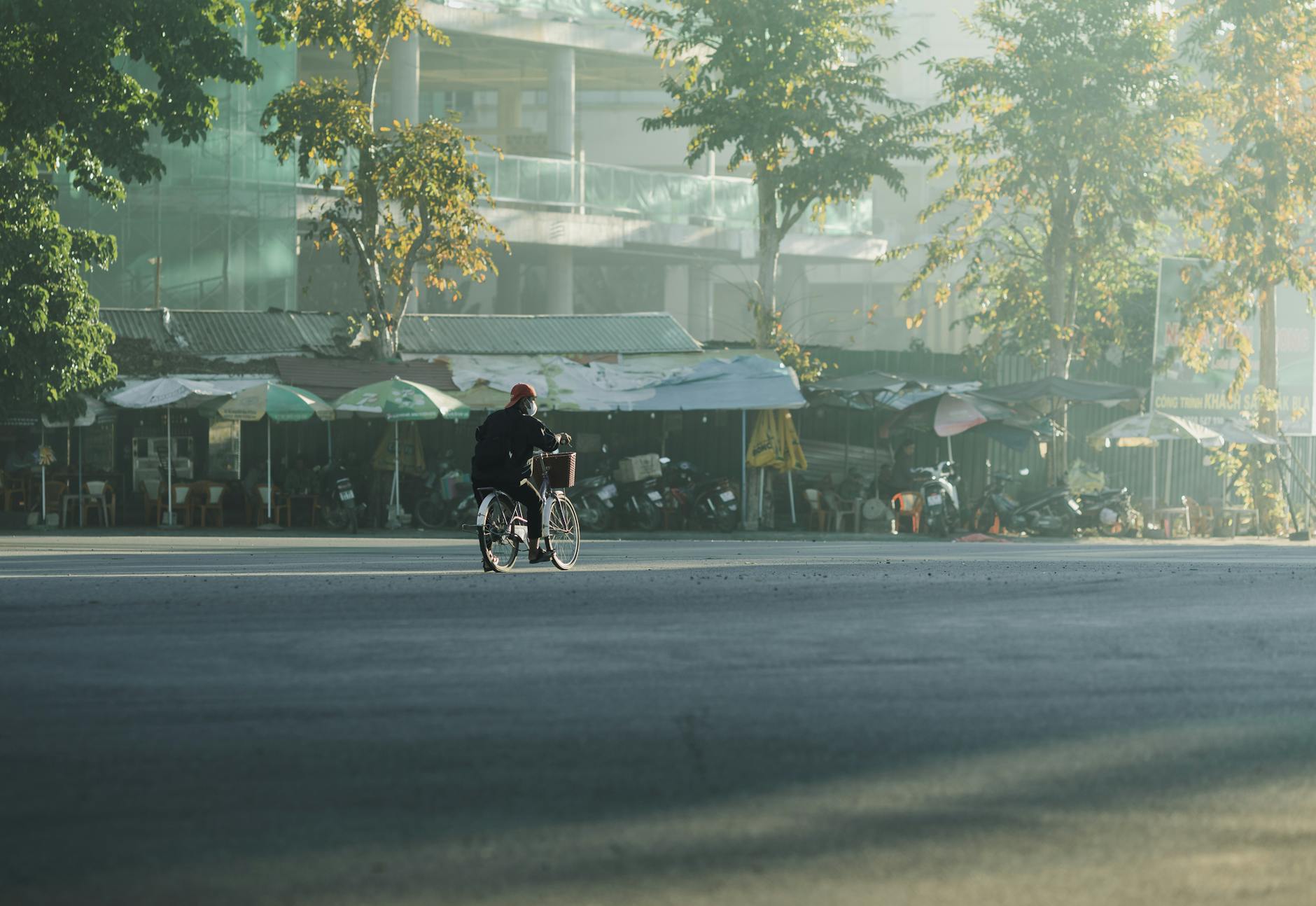 Cyclist rides through empty morning street in Kon Tum, Vietnam.