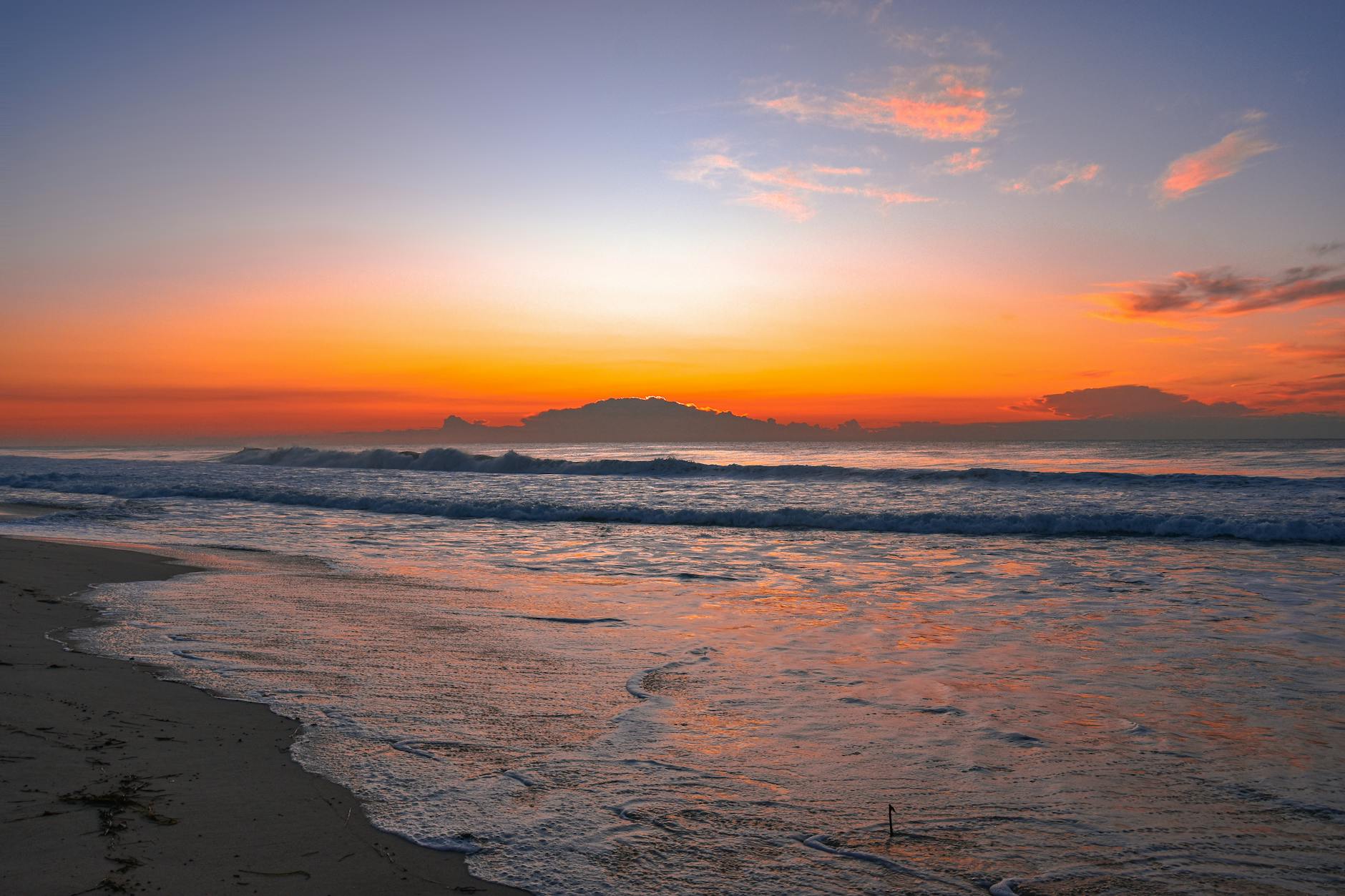 A beautiful sunrise over a tranquil ocean scene with vibrant colors reflecting on the water.