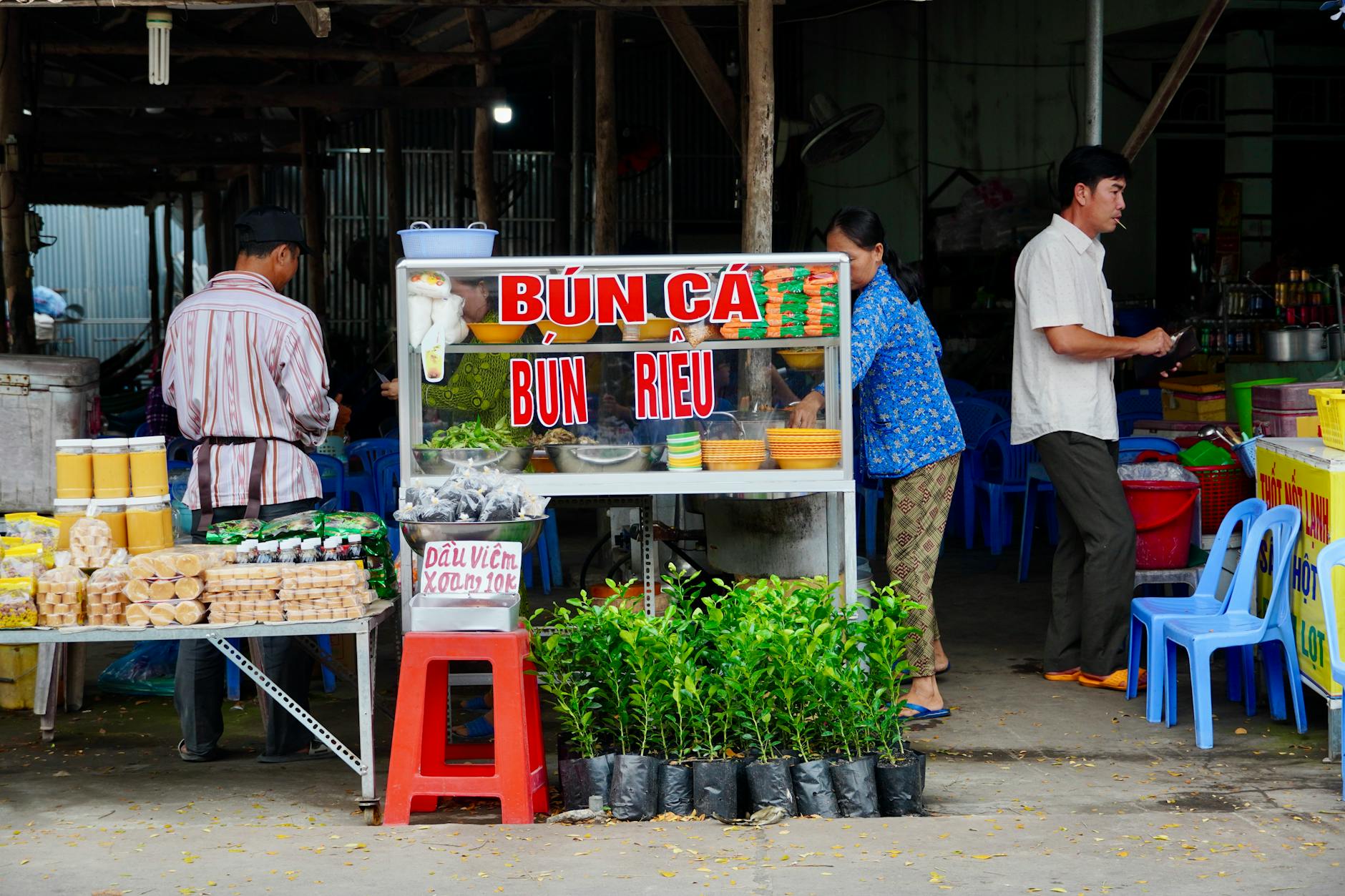 Vibrant street food market stall in Vietnam serving traditional dishes.