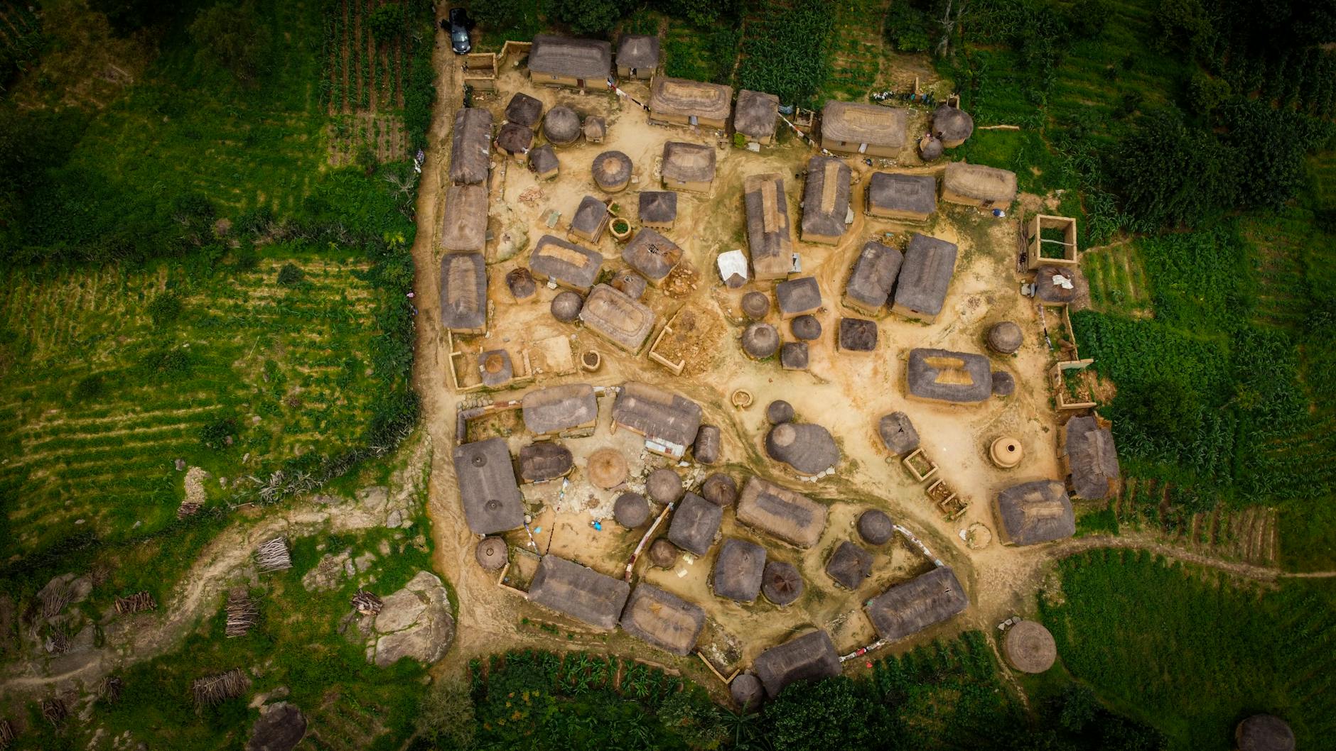 Aerial photo of traditional huts surrounded by lush greenery, showcasing cultural heritage.