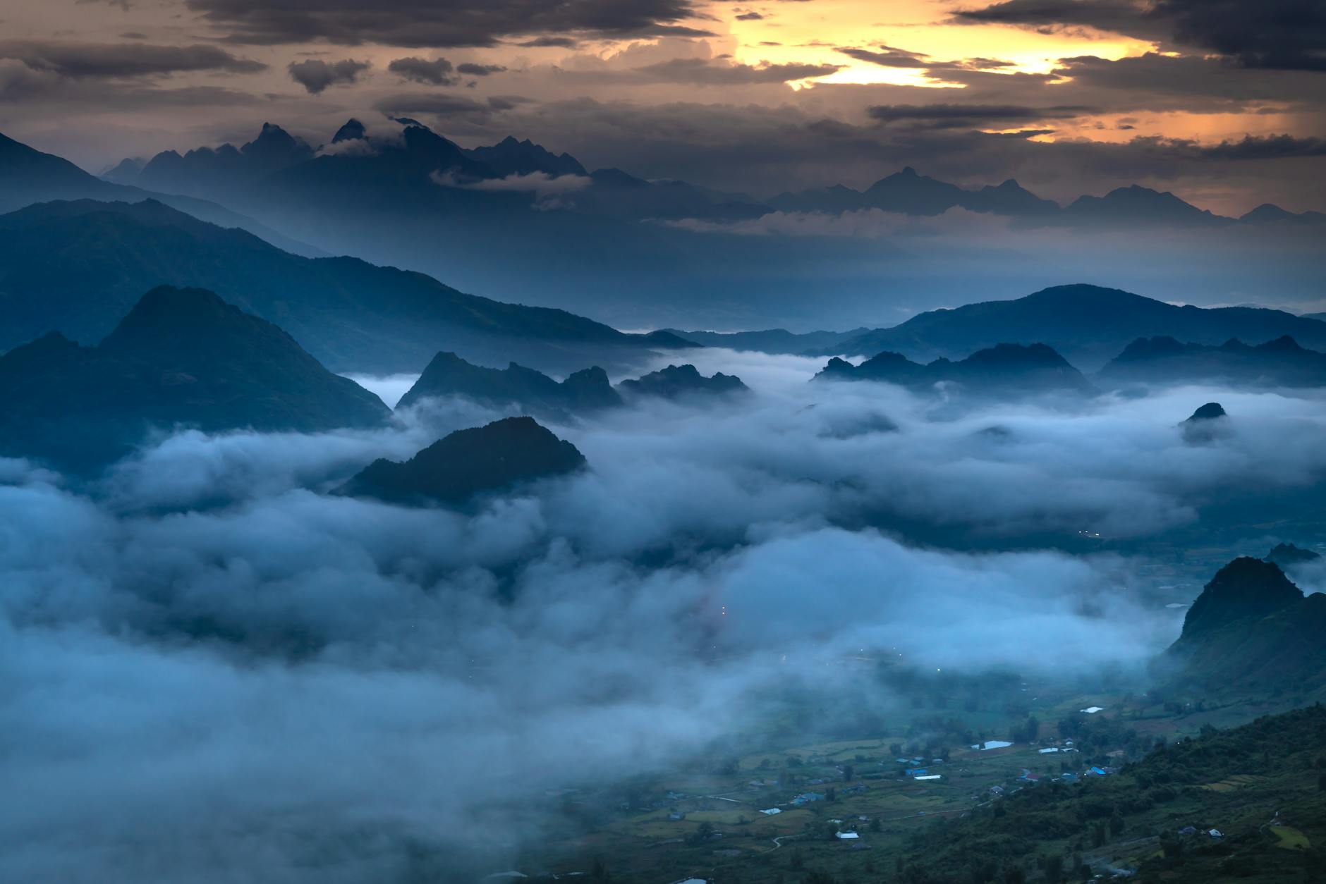 Breathtaking sunrise over foggy mountains, showcasing a dramatic sky and serene landscape.