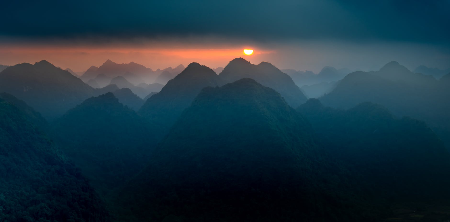 Majestic silhouette of mountains during sunrise, capturing warm and peaceful tones.