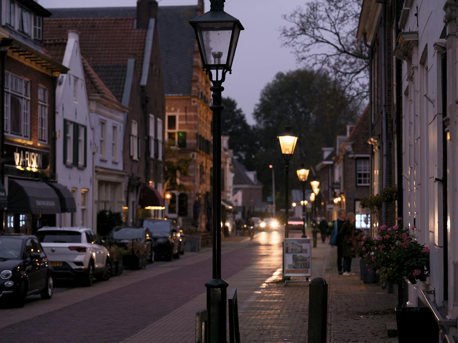 Charming evening street view in Naarden, highlighting historic architecture and glowing streetlights.