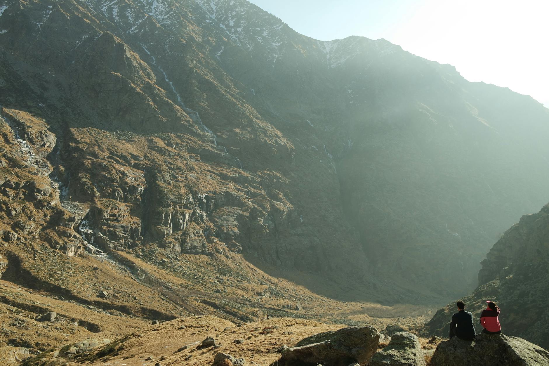 Two people admire the majestic mountains of Vale de Aosta, Italy.