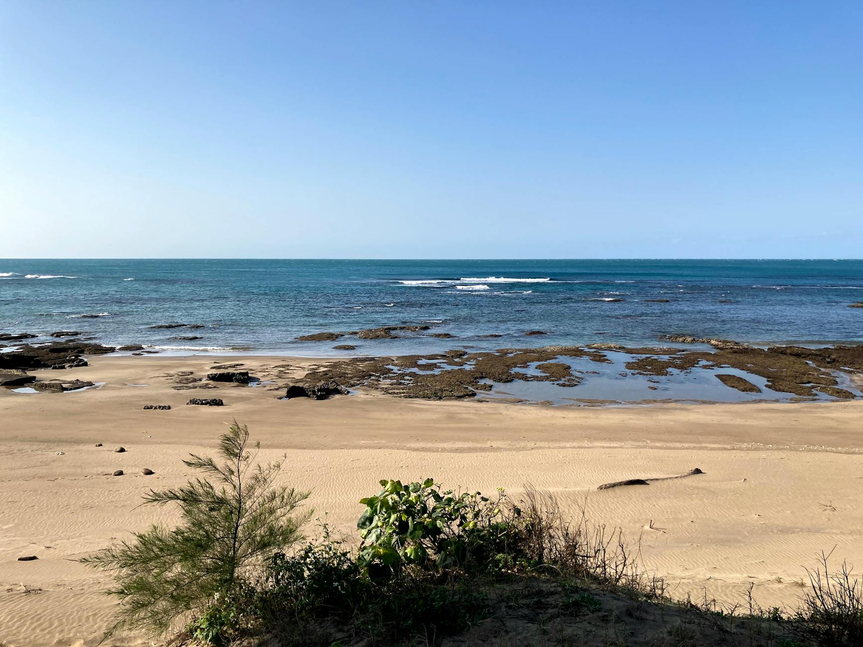 Peaceful coastal scene featuring sandy shores and clear blue ocean in New Taipei City, Taiwan.