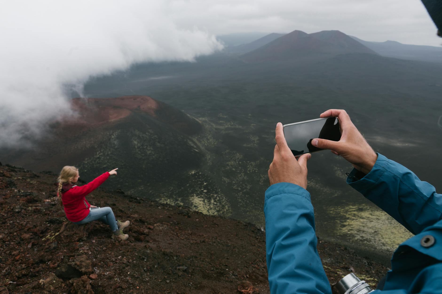 A hiker captures a memorable moment on a mountainous trail, enveloped by fog and stunning vistas.