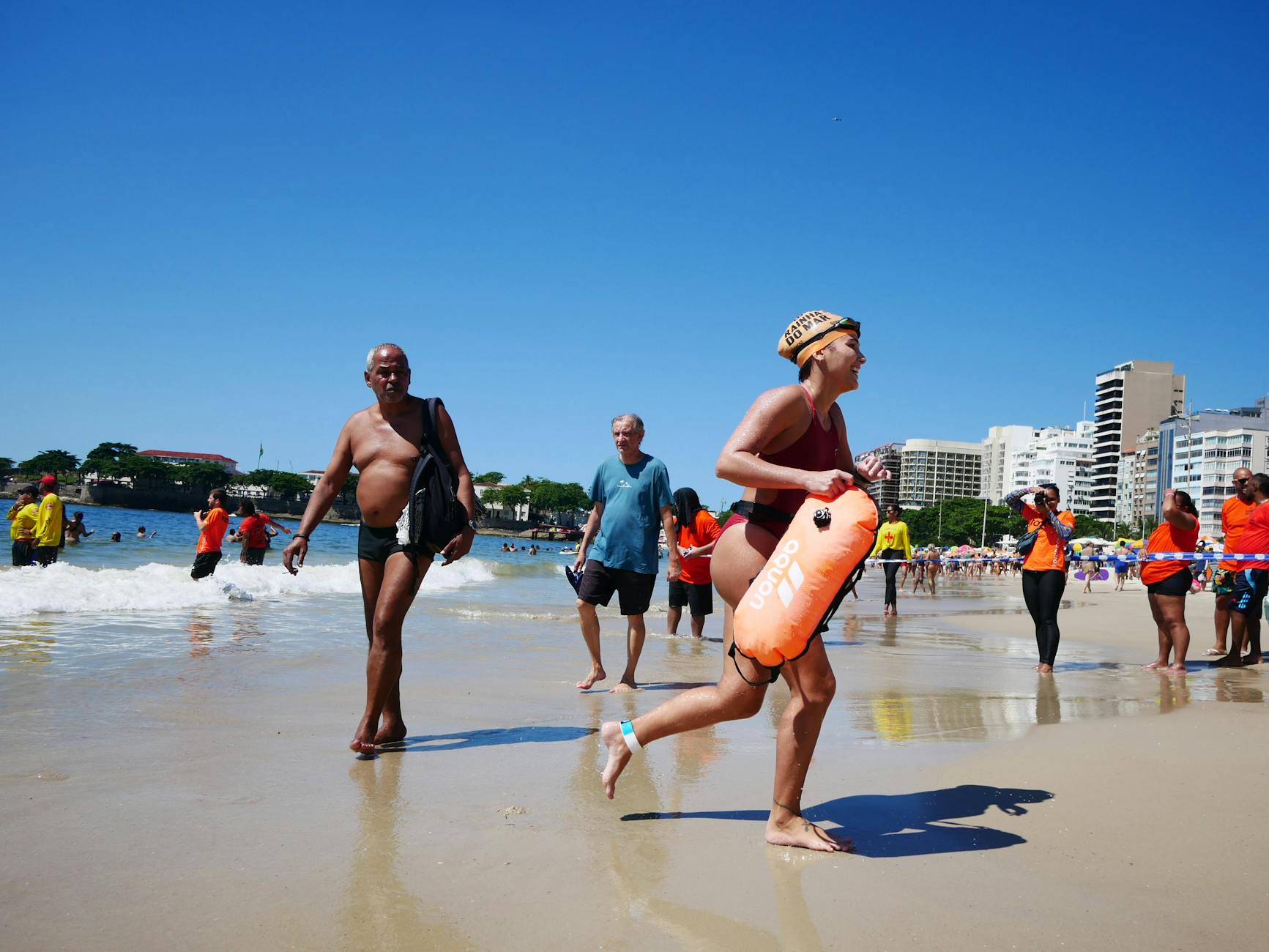 People enjoying a sunny day on Copacabana Beach, Rio de Janeiro, amidst lively summer activities.