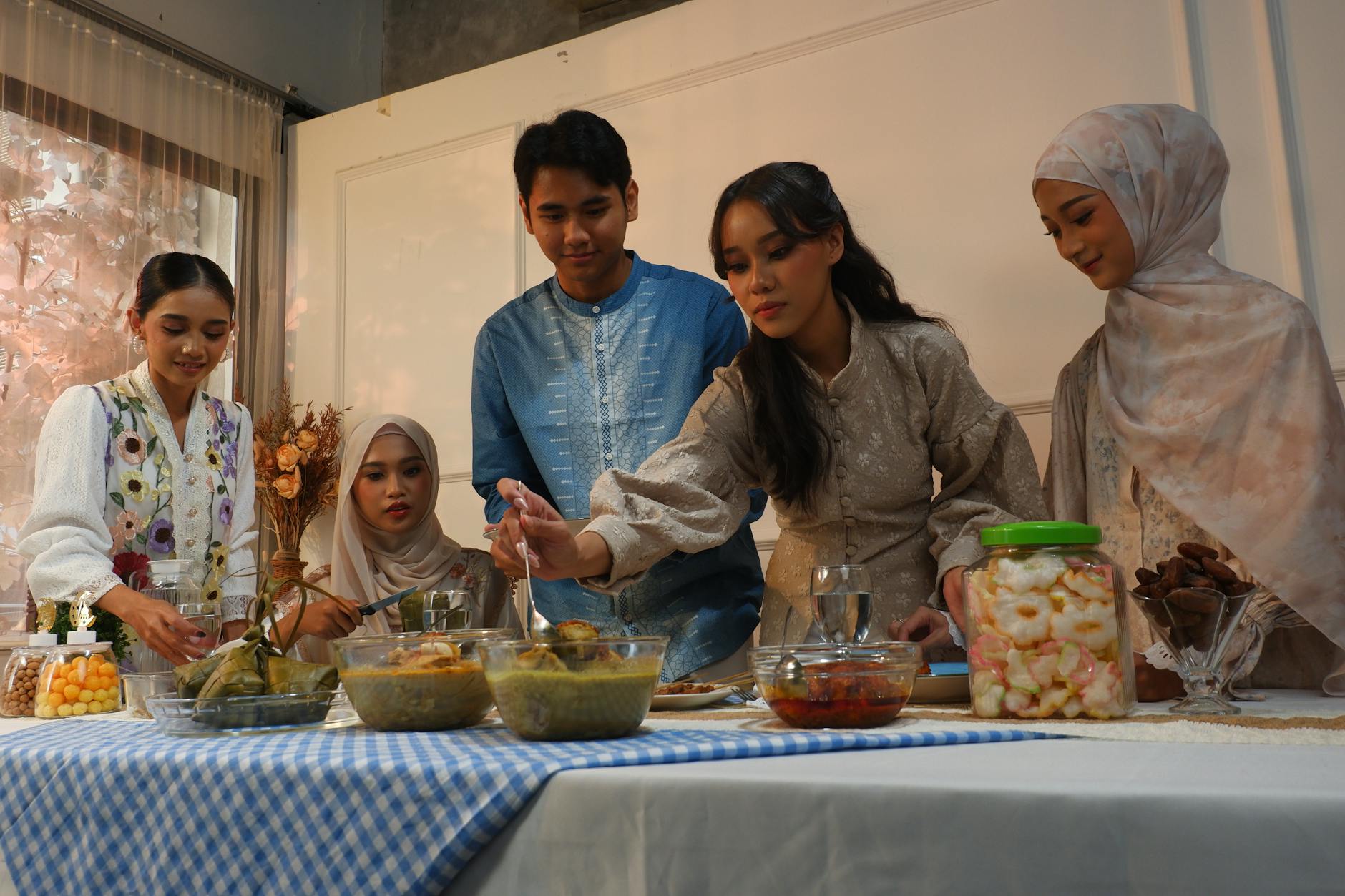 Group of friends enjoying a festive meal indoors with traditional dishes.