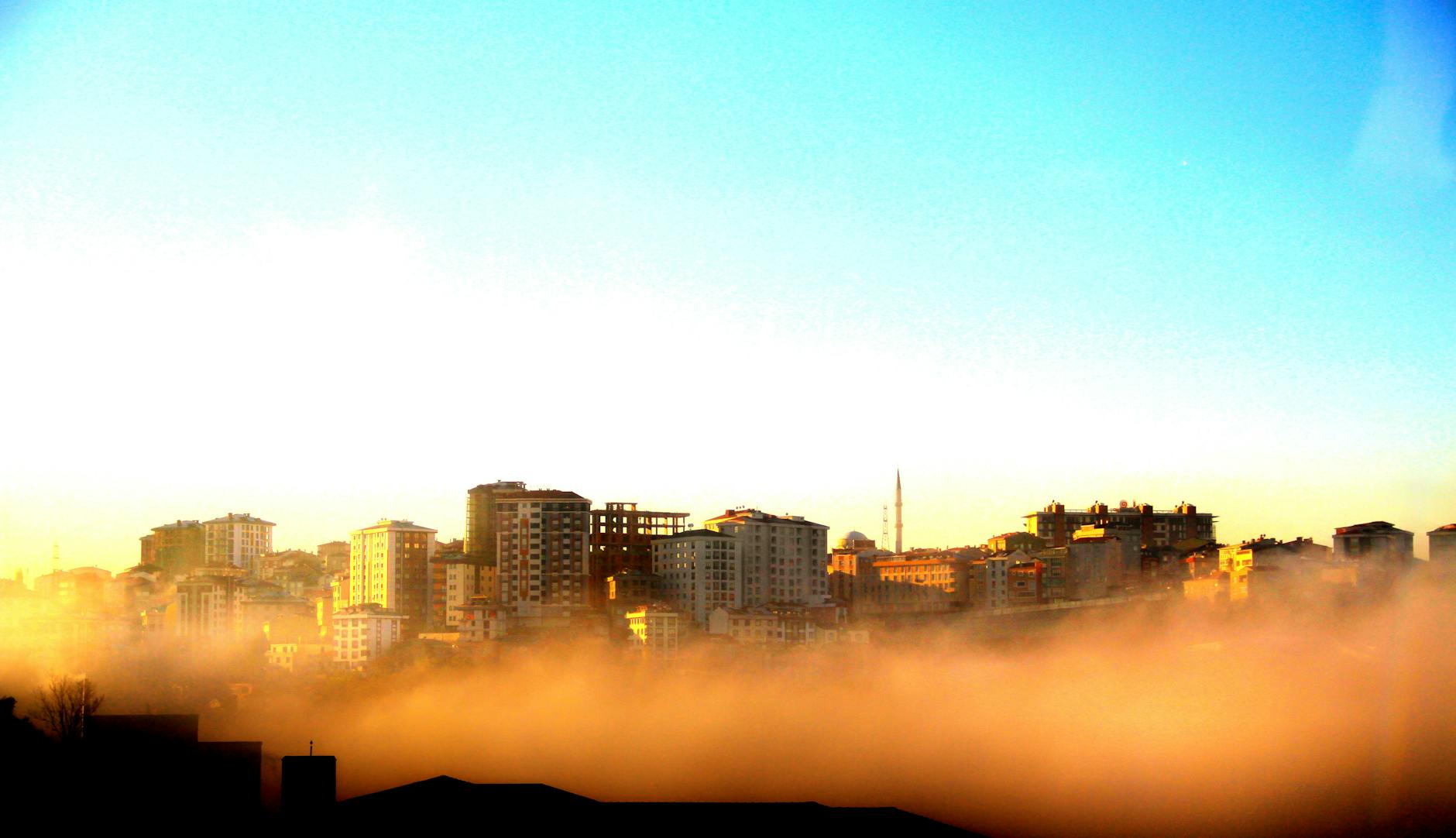 Misty morning view of Altındağ district's skyline in Ankara with buildings emerging through fog.