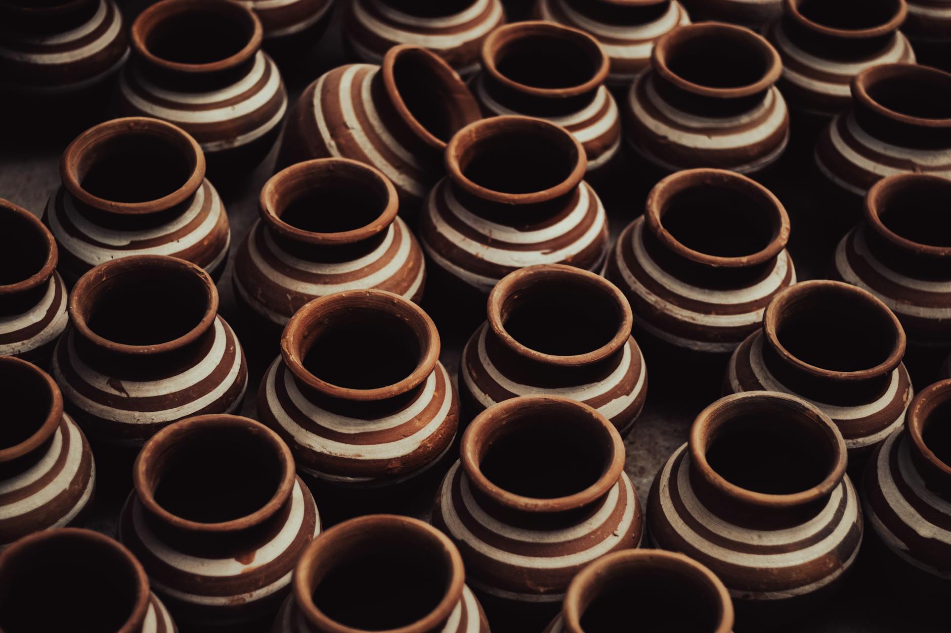 Close-up of handmade terracotta pots showcasing traditional craftsmanship with intricate patterns.