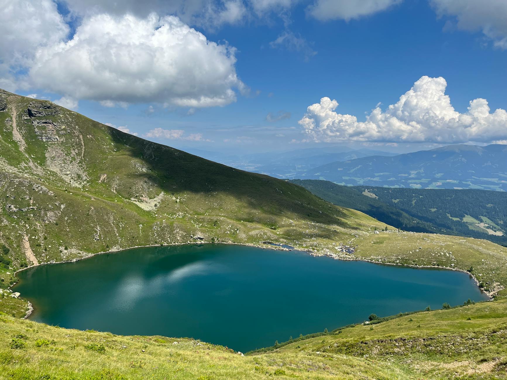 A breathtaking view of an alpine lake surrounded by lush mountains in Styria, Austria.