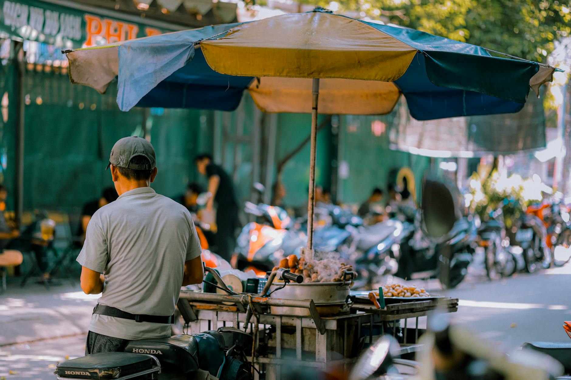 A street vendor prepares food at a busy outdoor market in Ho Chi Minh City, capturing daily life in Vietnam.