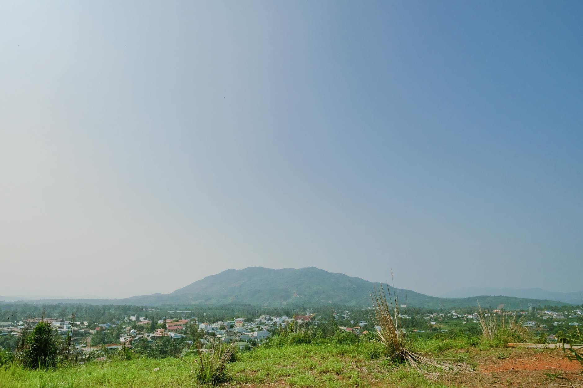 Serene rural landscape featuring a distant mountain range under a clear sky.