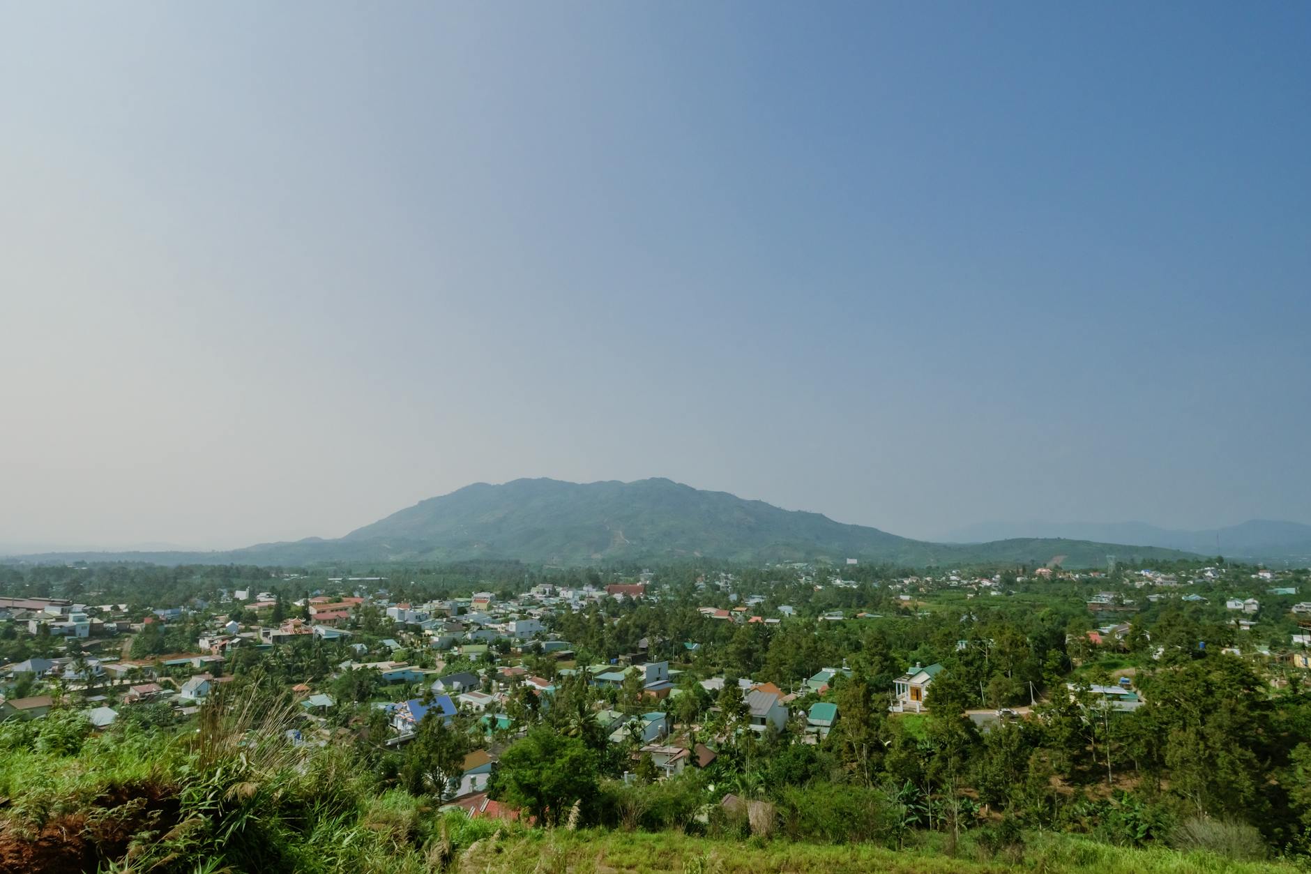 A panoramic view of a residential area with mountains in the background under a clear sky.