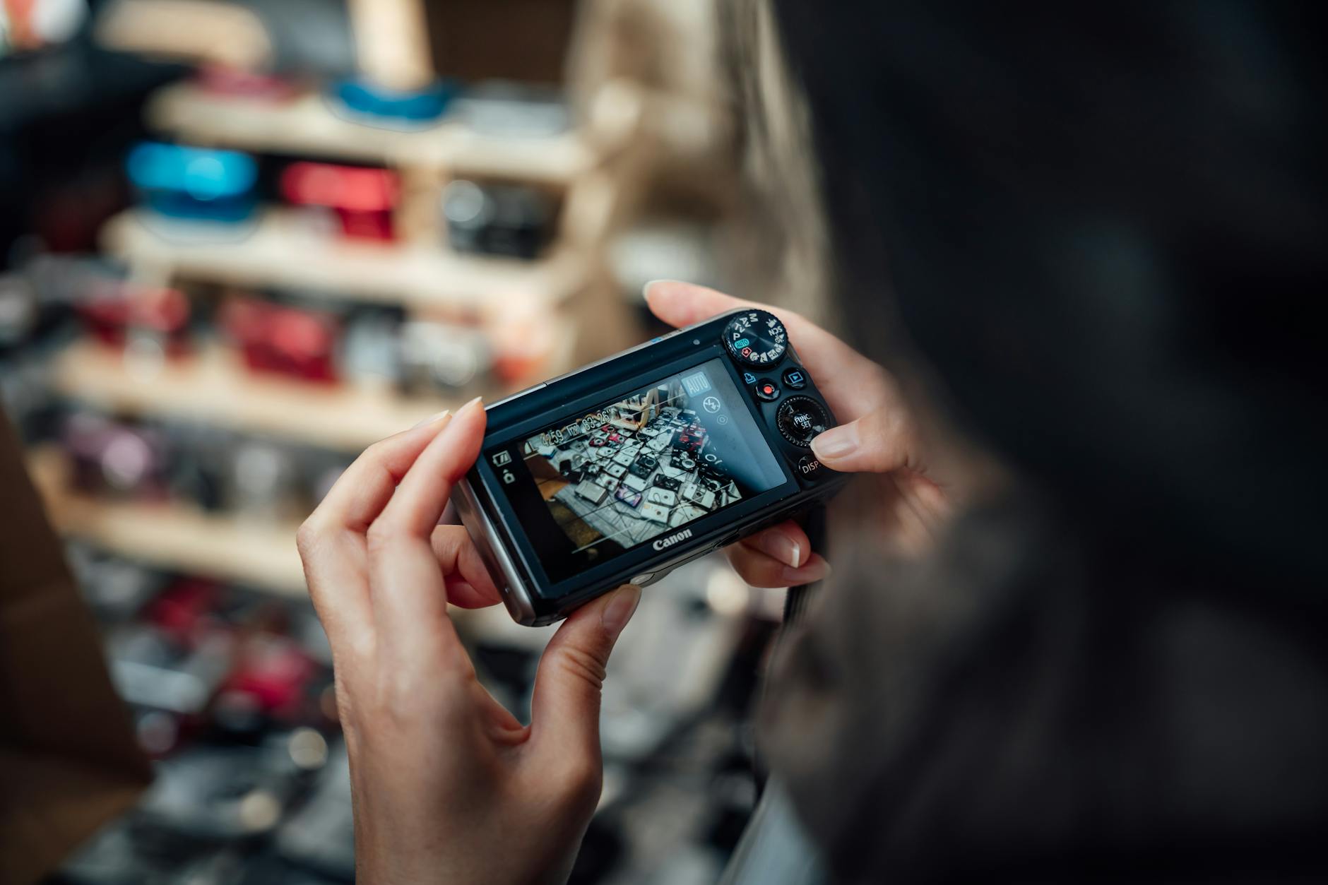 Person using a camera to photograph items at a bustling London market.