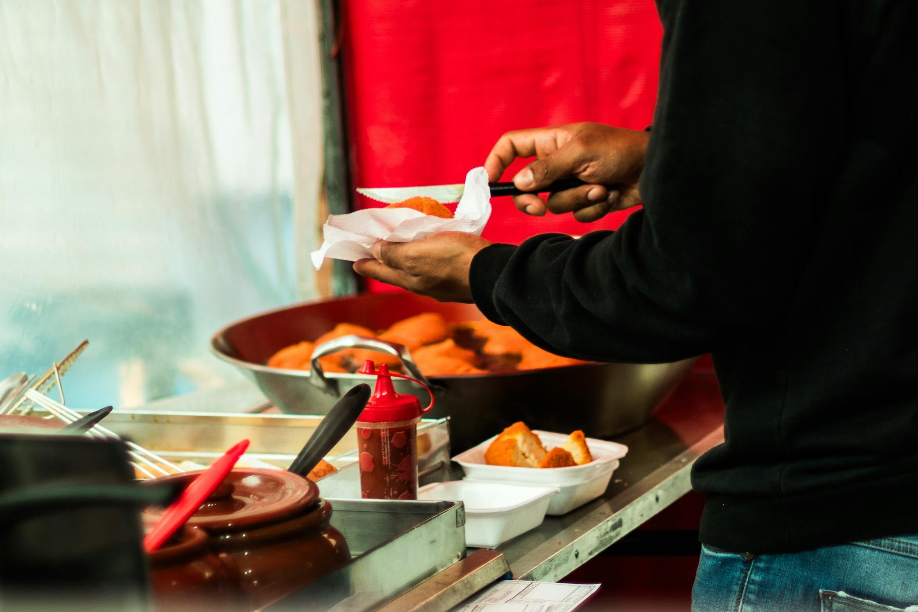 A street vendor prepares delicious fried snacks at a food truck in São Paulo, creating a vibrant culinary scene.