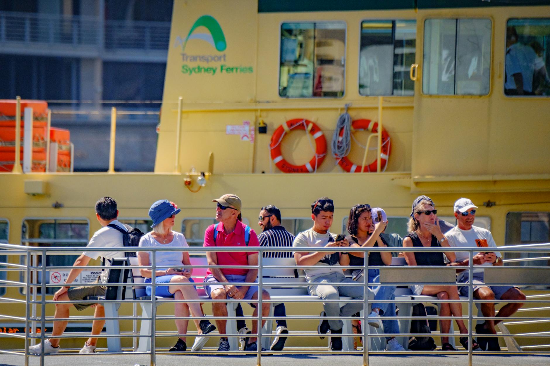 Passengers aboard Sydney Ferry enjoy a sunny day, showcasing leisure and travel.