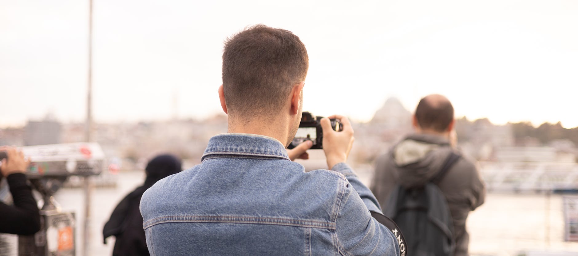 Tourists taking photos of İstanbul's skyline, showcasing casual street photography vibes.