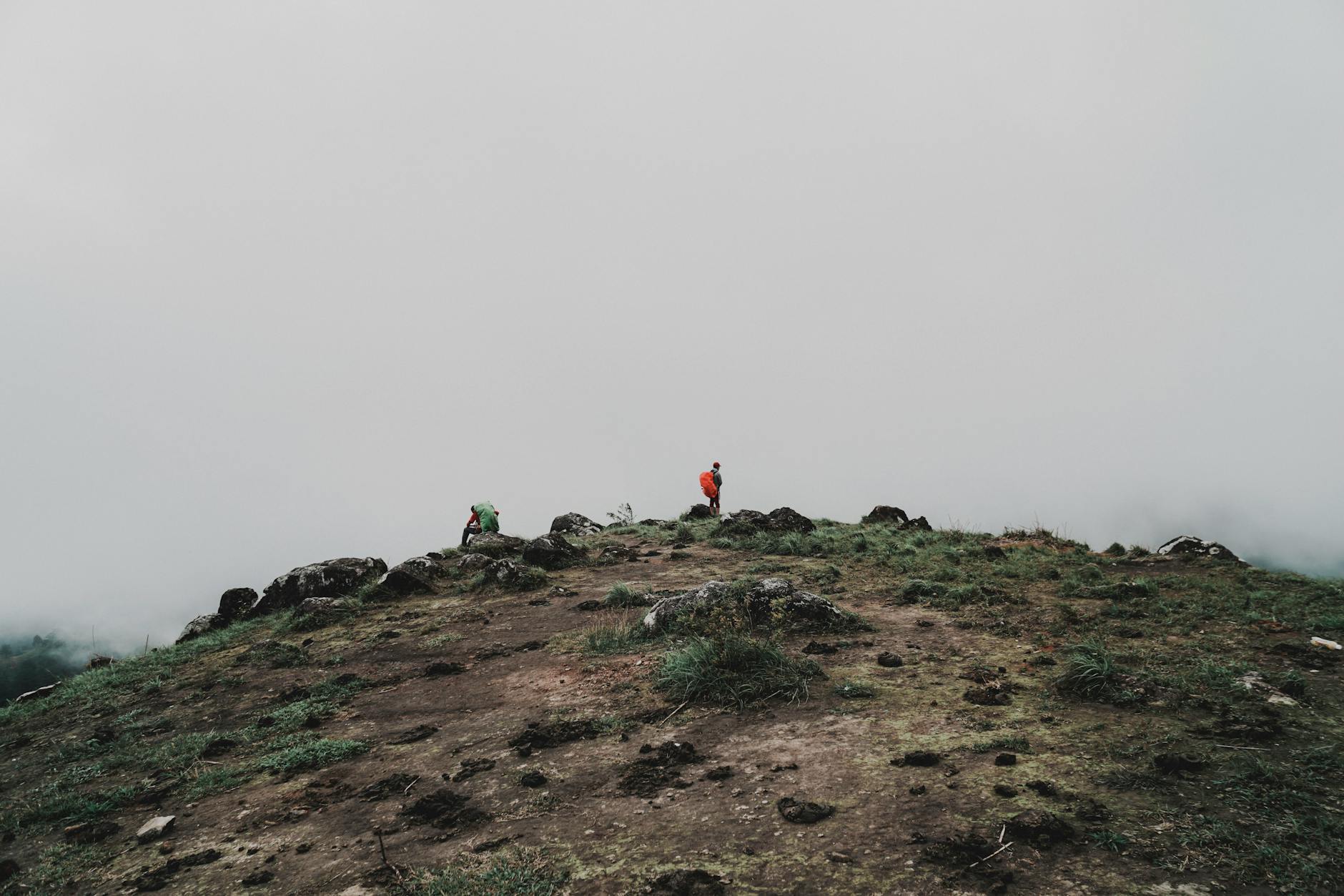 Two hikers on a misty mountain peak, showcasing adventure and exploration.