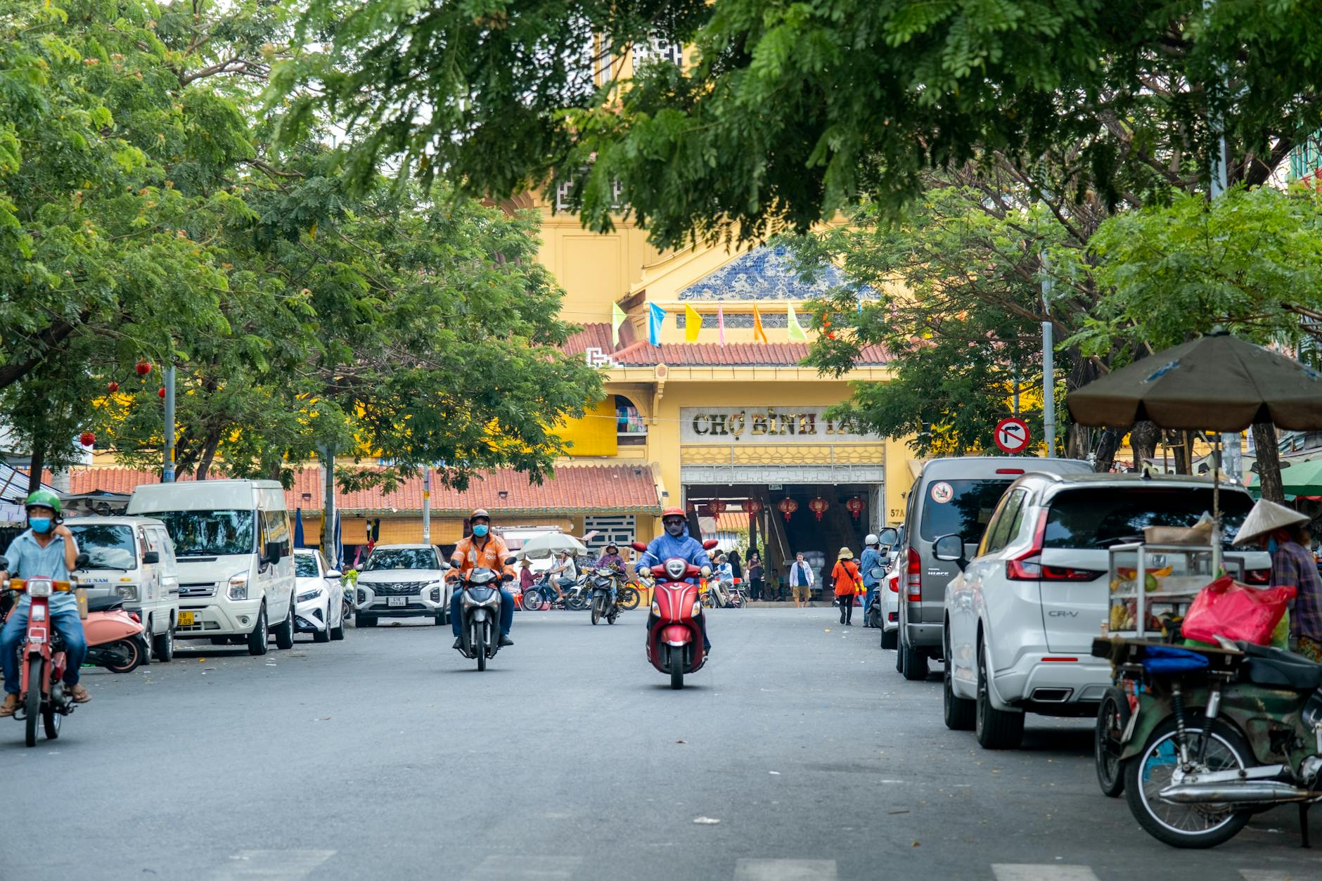 Motorcycles and cars traverse a vibrant street near Ben Thanh Market in Ho Chi Minh City.