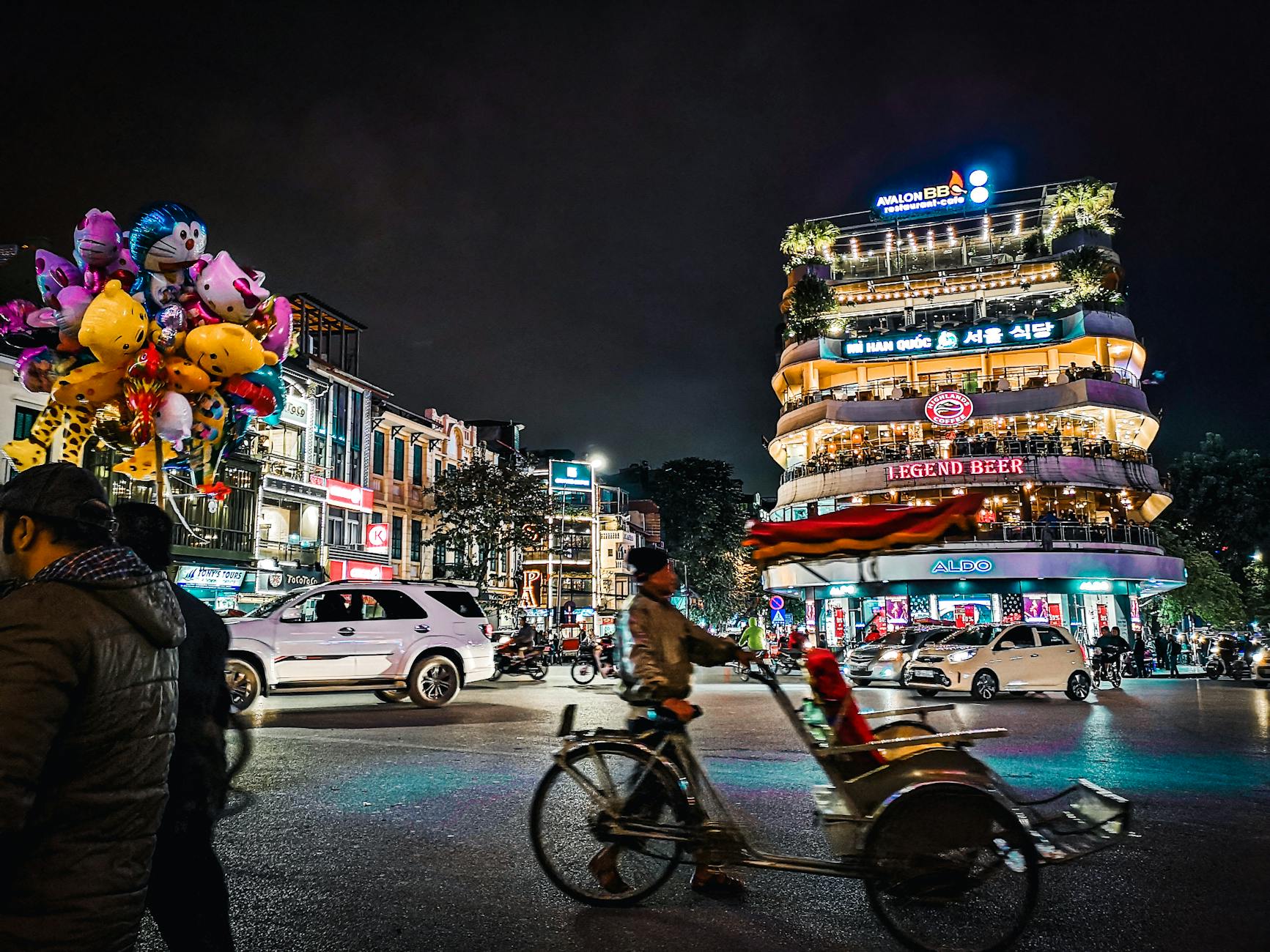 Explore the bustling nightlife of Hanoi with colorful balloons, busy streets, and lively architecture.