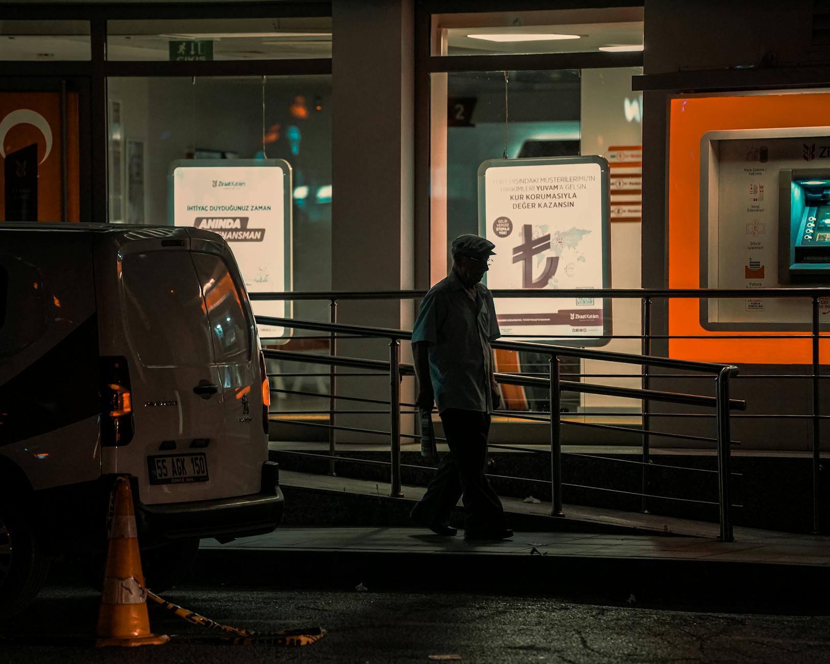 Silhouette of a man walking at night in a city street with urban lighting.