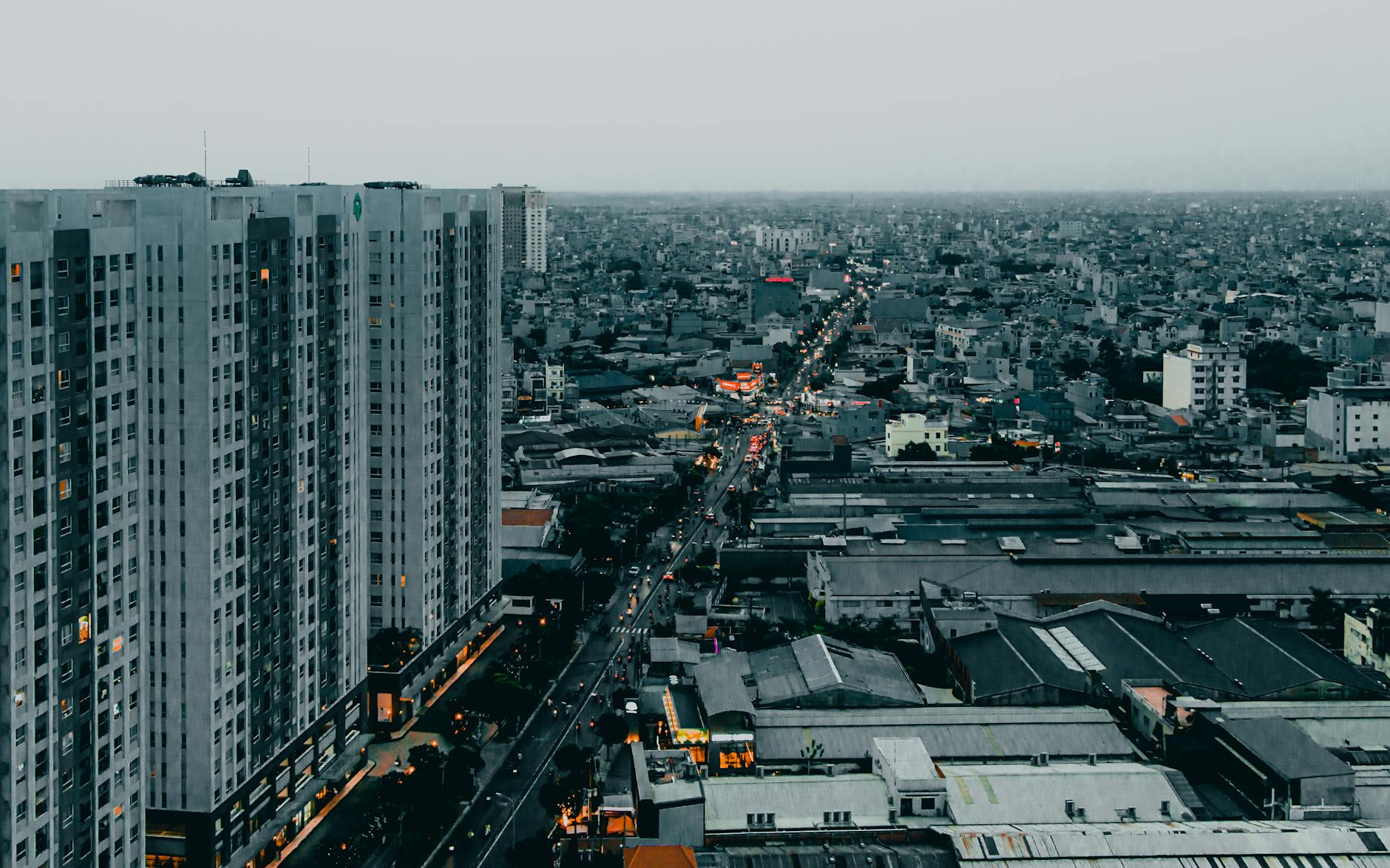 Aerial view of bustling Ho Chi Minh City showcasing high-rise buildings and busy streets at dusk.