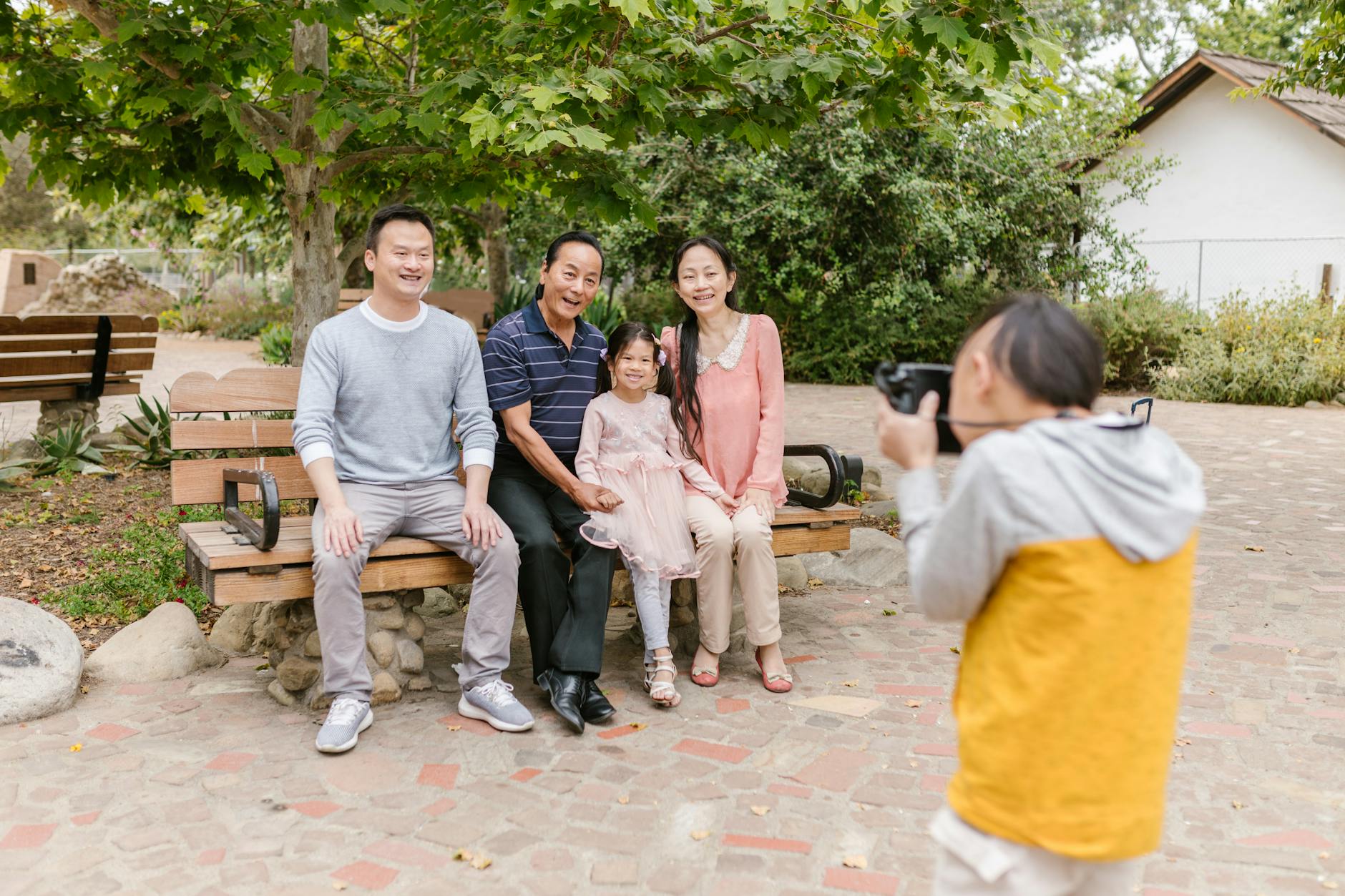 A joyful family having their photo taken in a serene park environment.