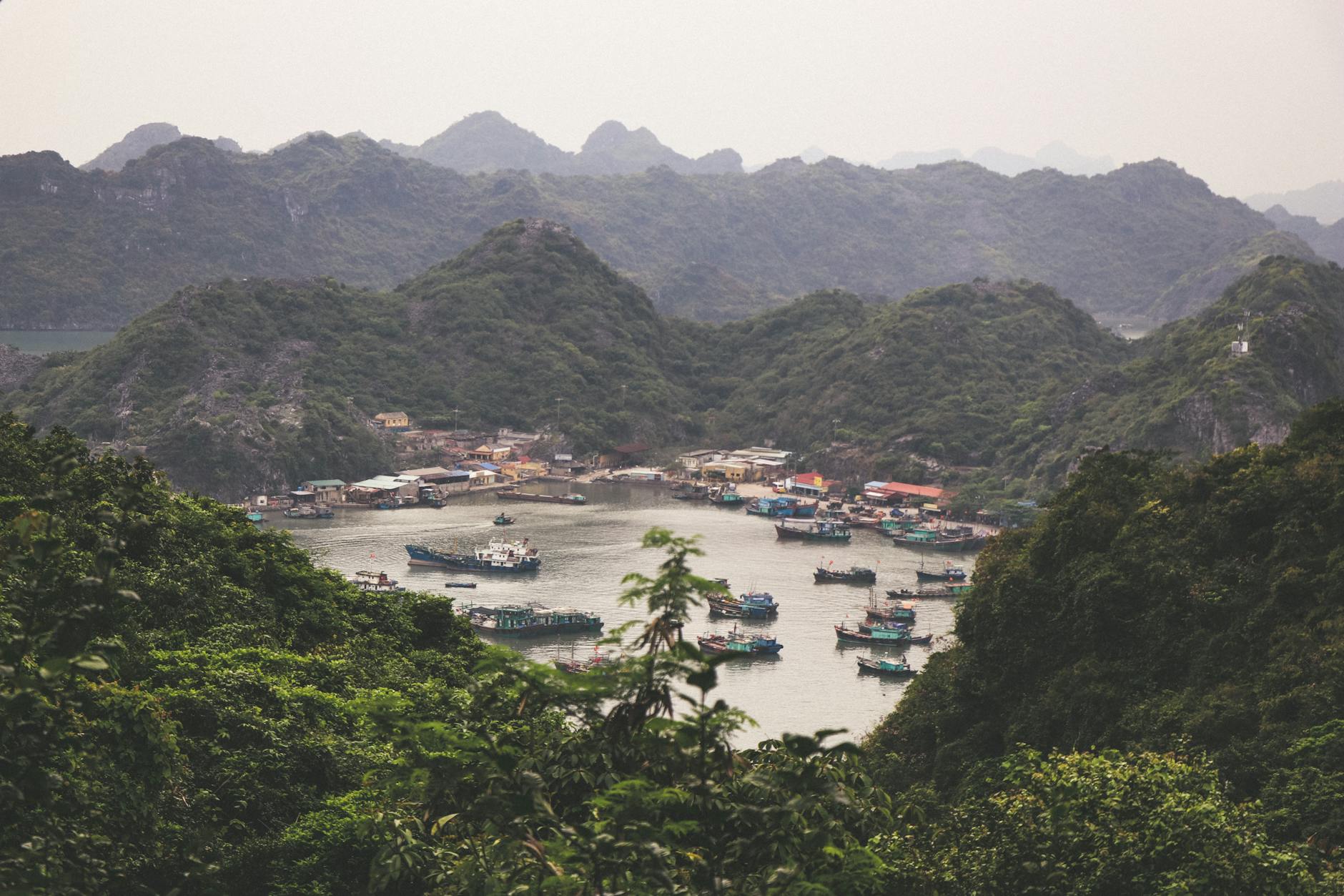 A picturesque view of fishing boats nestled among lush green hills in Hai Phong, Vietnam.