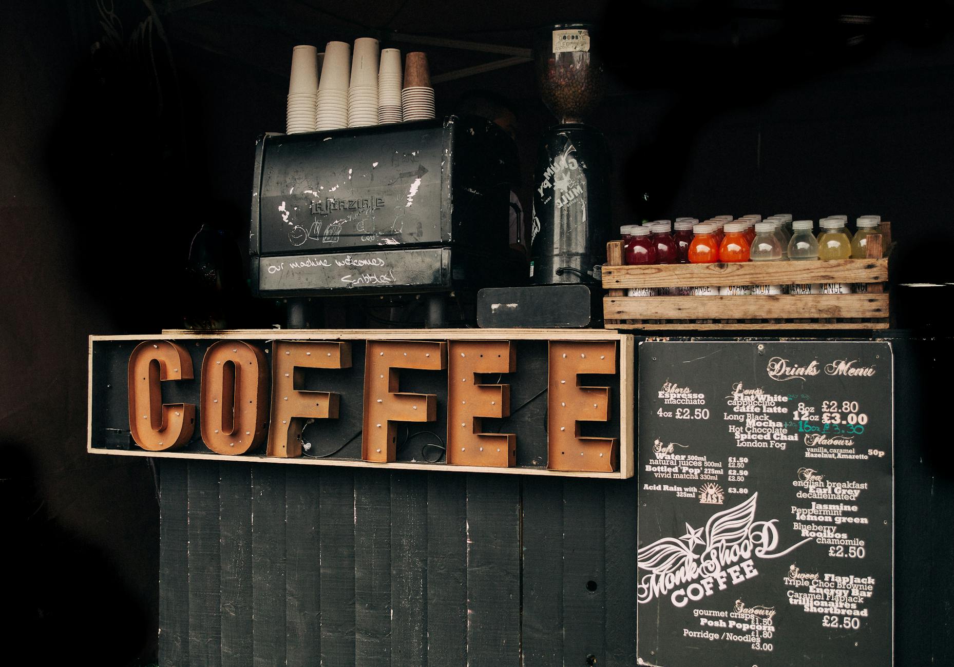 Coffee shop display with vintage decor, menu, and various bottled drinks.
