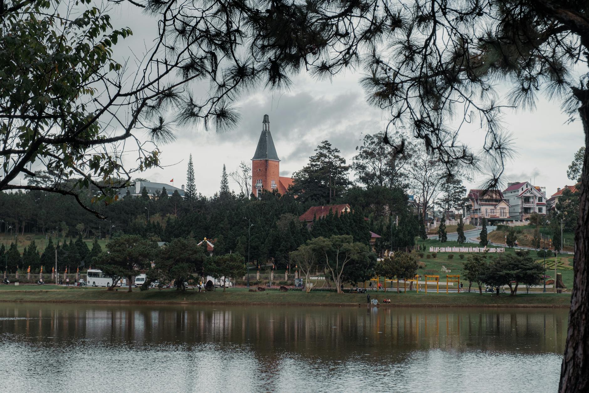 Beautiful view of a lake with iconic architecture and lush greenery in Da Lat, Vietnam.