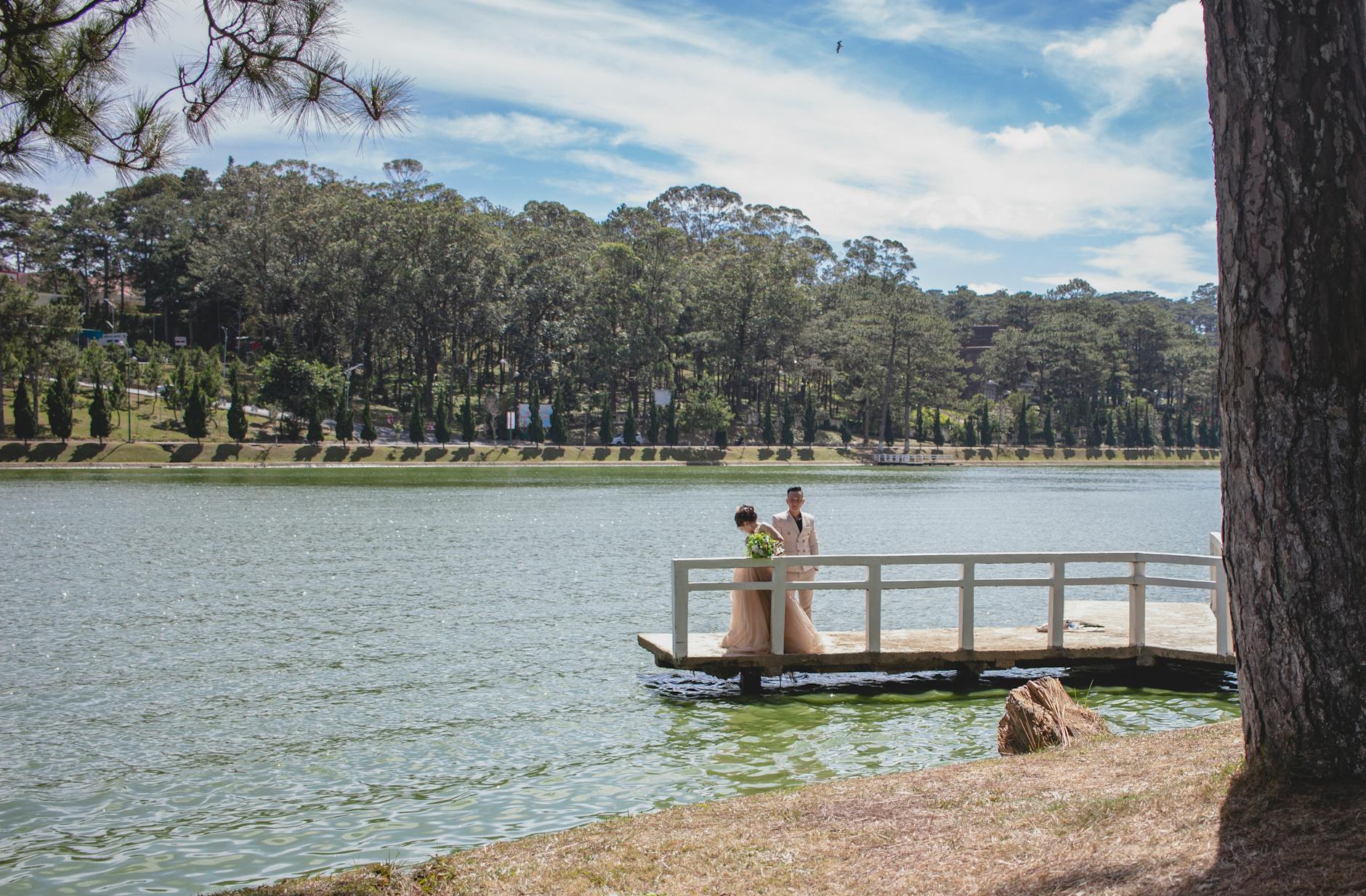 Beautiful wedding couple having a moment by the lake in Đà Lạt, Vietnam.