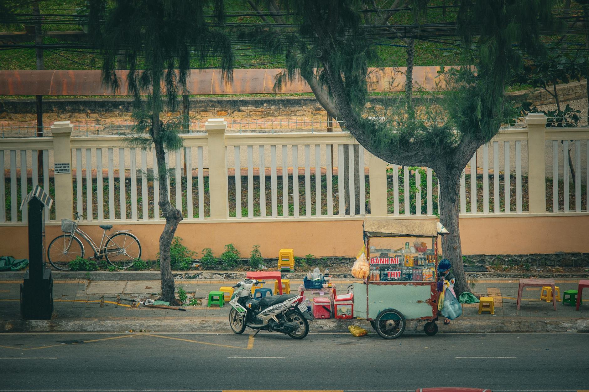 Traditional Vietnamese street food cart in Vũng Tàu cityscape setting.