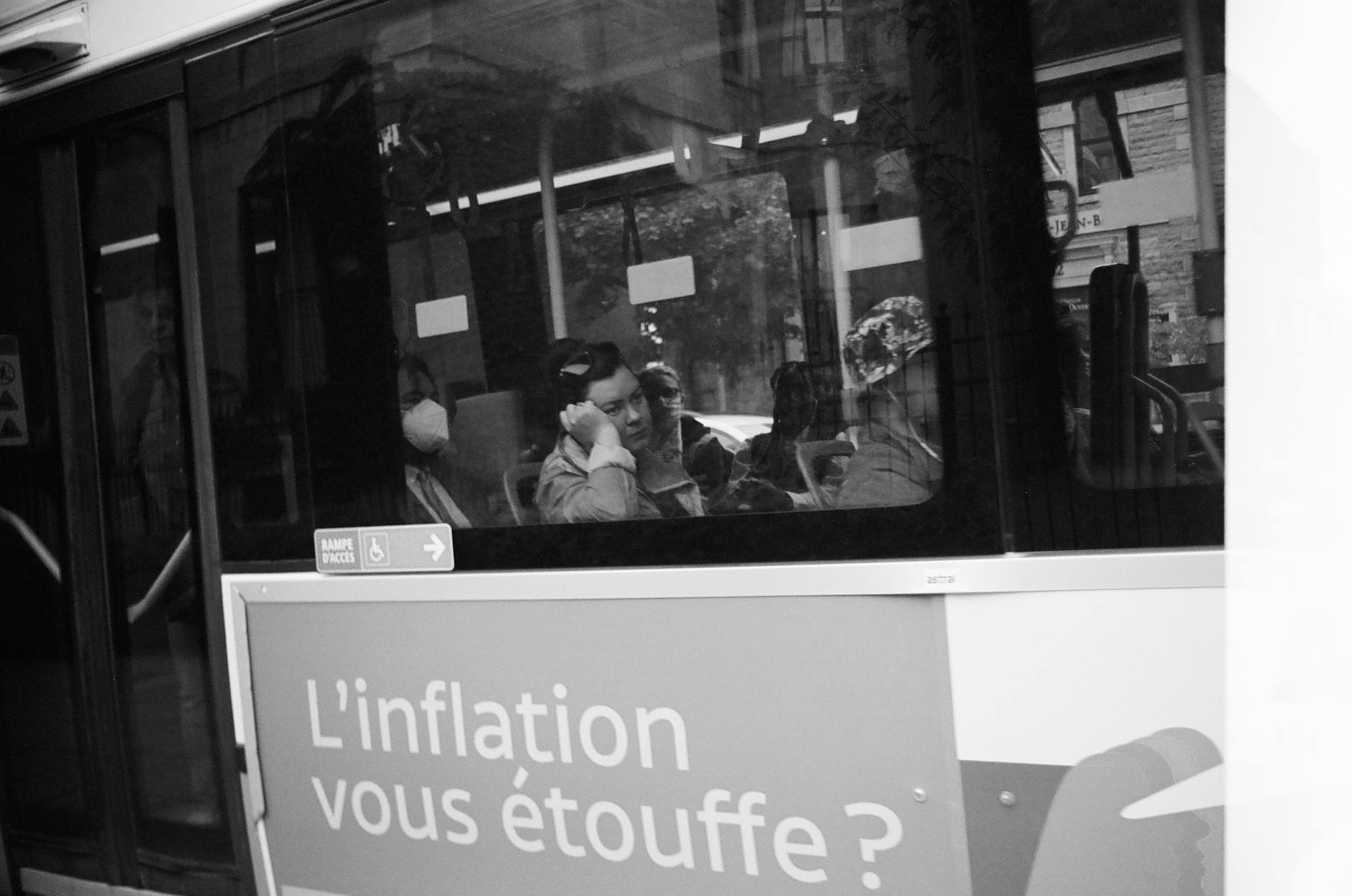 Passengers observe outside from a city bus in a black and white photograph
