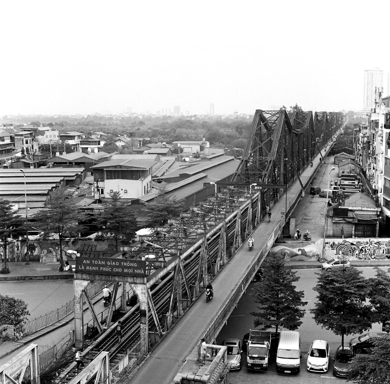 Black and white photo of Long Biên Bridge in Hanoi showcasing urban transport and architecture.