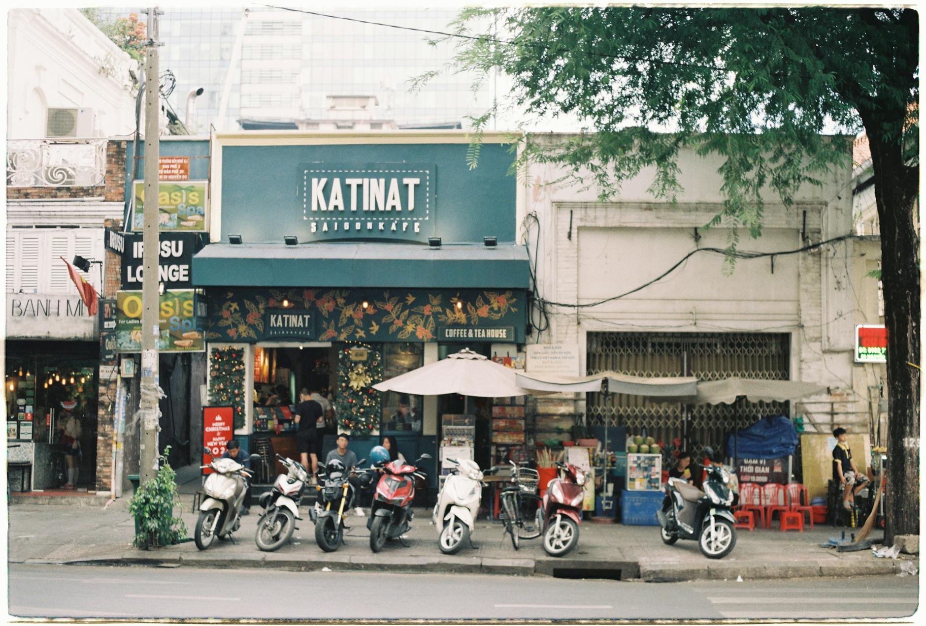 Street view of Katinat Café in Ho Chi Minh City with motor scooters parked in front.