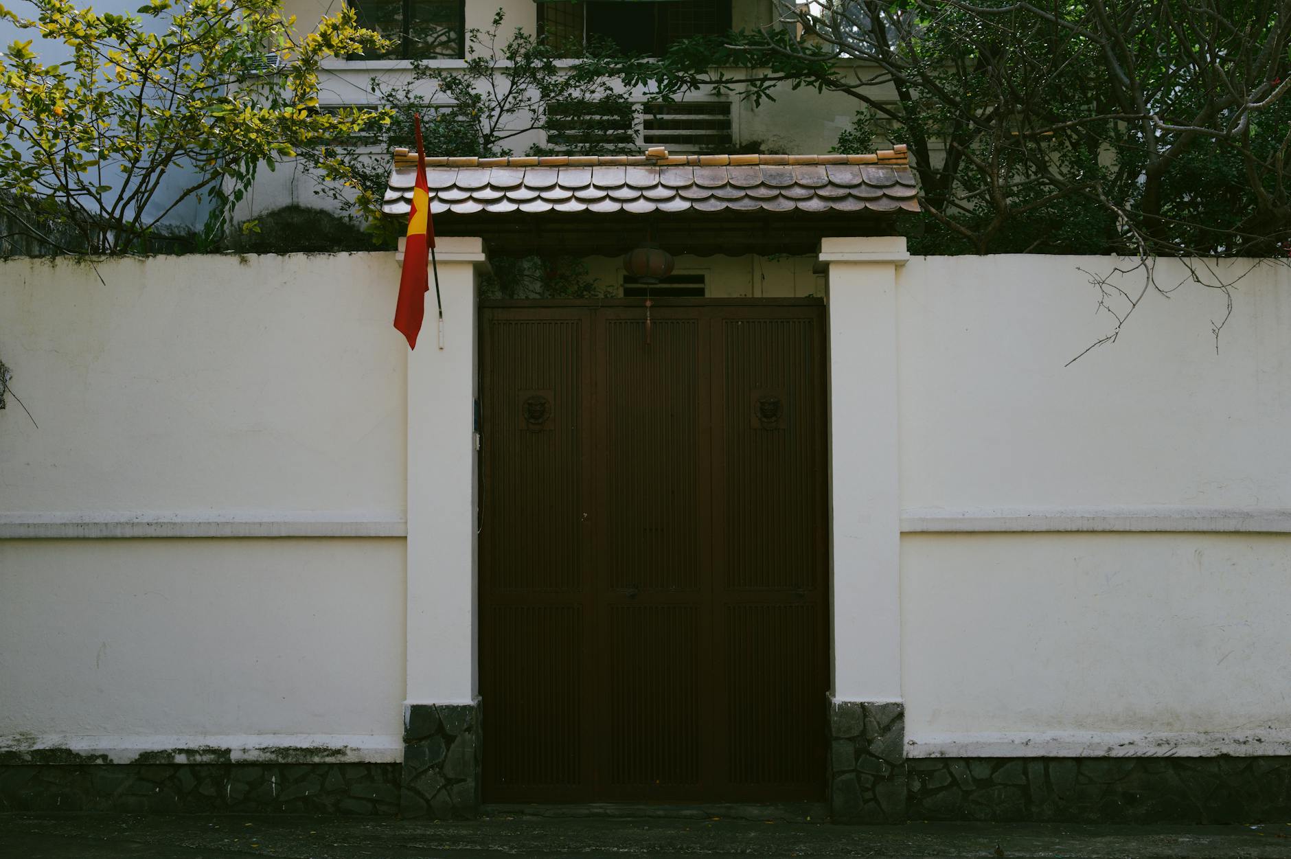 A traditional entrance with a Vietnamese flag on a sunny day.